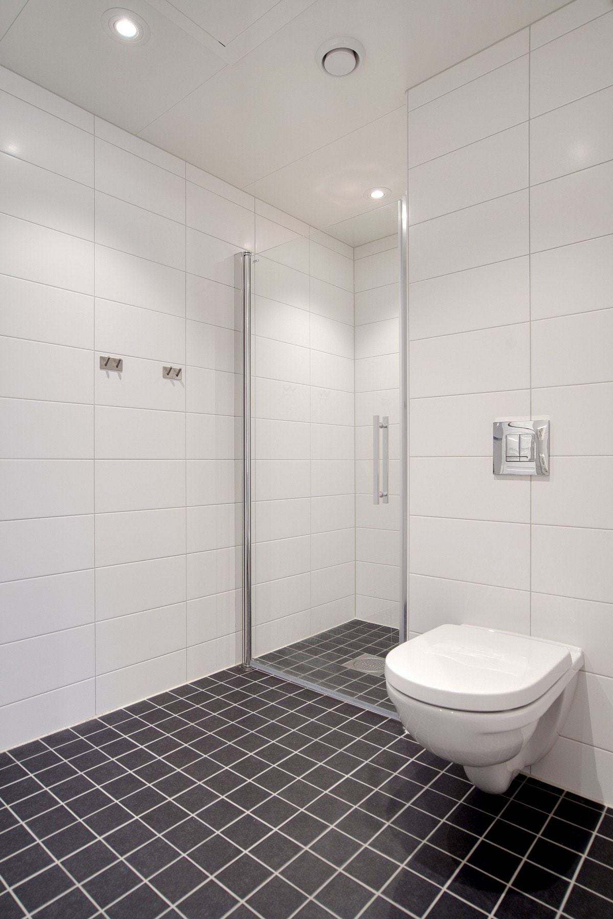 Badet er utstyrt med baderomsinnredning, veggmontert wc, dusjhjørne og opplegg for vaskemaskin Galleribilde