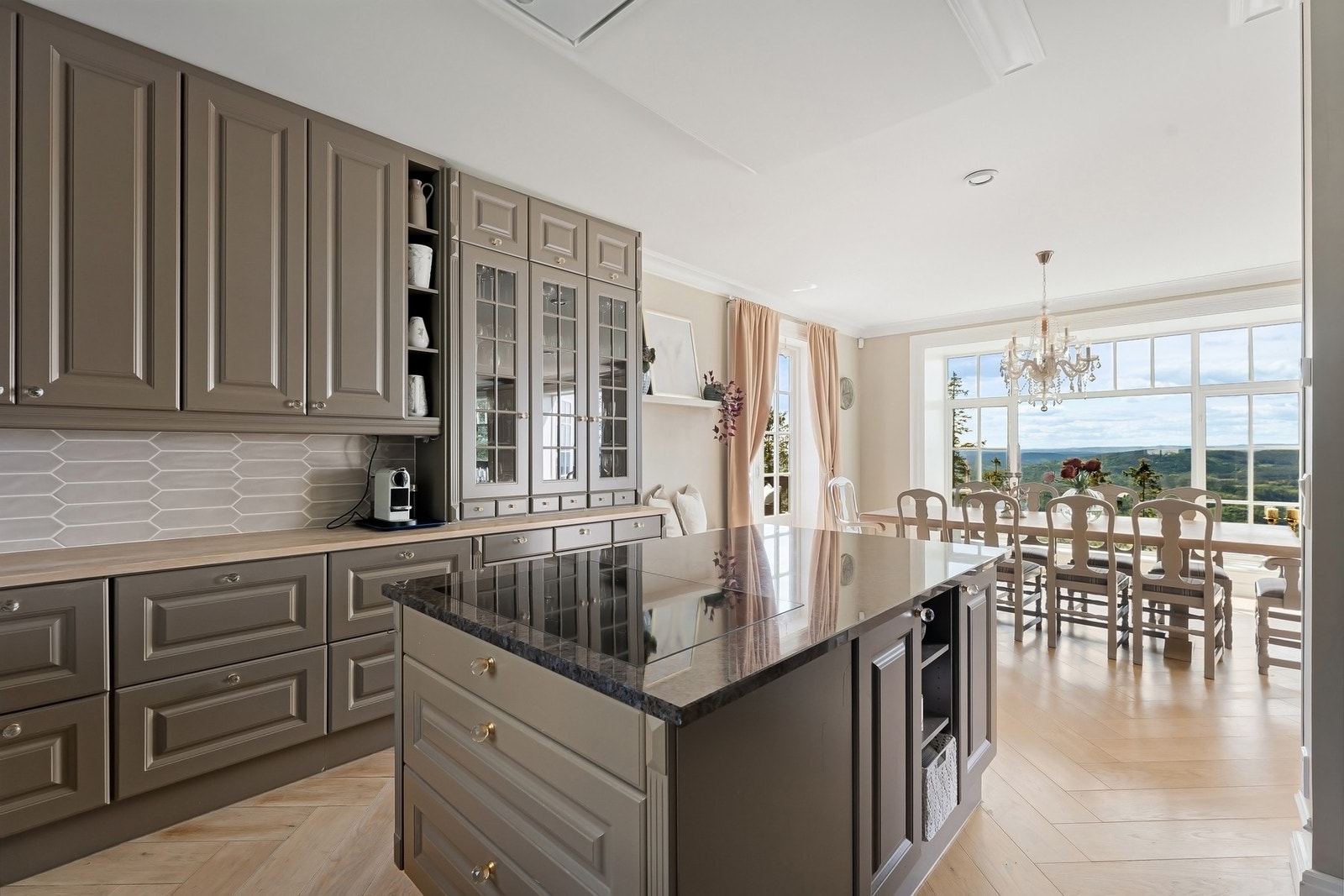 Innredningen har profilerte fronter kombinert med overskap med glassfelt, som gir en fin balanse mellom klassisk stil og moderne funksjon. Galleribilde