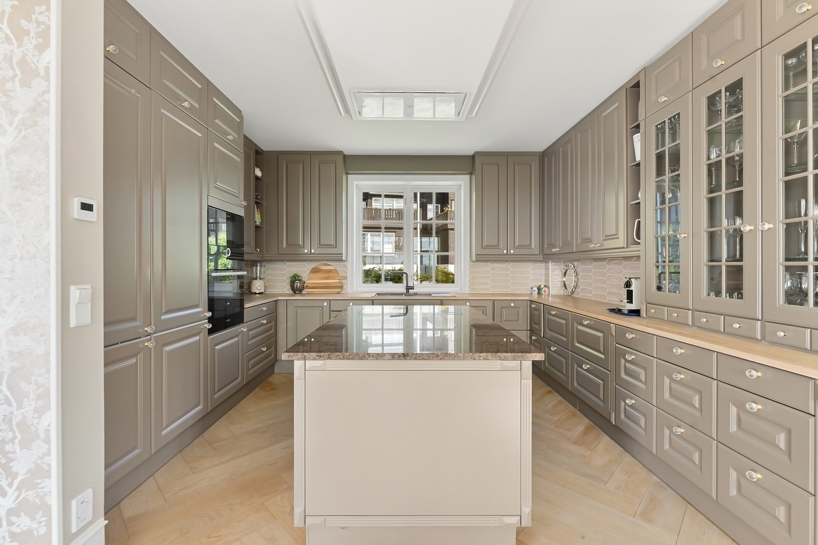 Lekkert kjøkken fra JKE med gjennomførte materialvalg og elegant utforming. Galleribilde