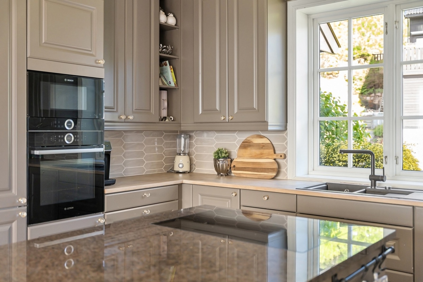 Hvitevarene er helintegrerte og inkluderer stekeovn, mikrobølgeovn, platetopp, oppvaskmaskin, vinkjøler, kjøleskap og fryser - alt sømløst tilpasset helheten. Galleribilde