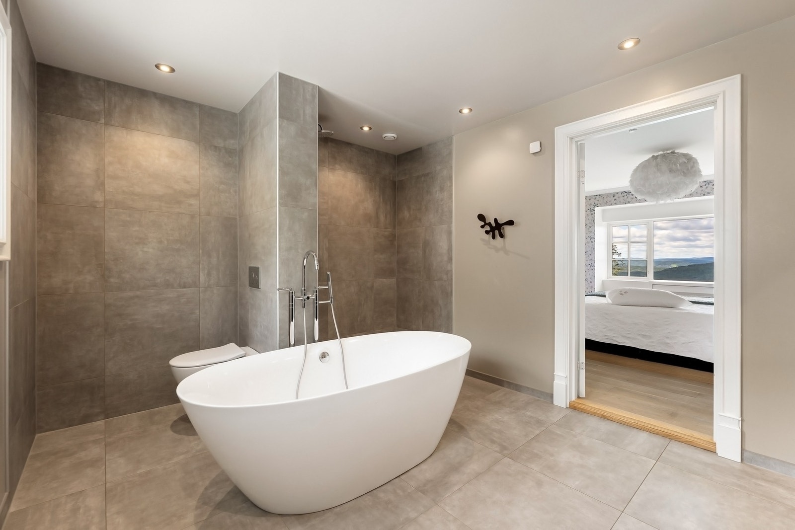 Fra hovedsoverom er det direkte inngang til stort masterbad med frittstående badekar og dusjnisje. Galleribilde