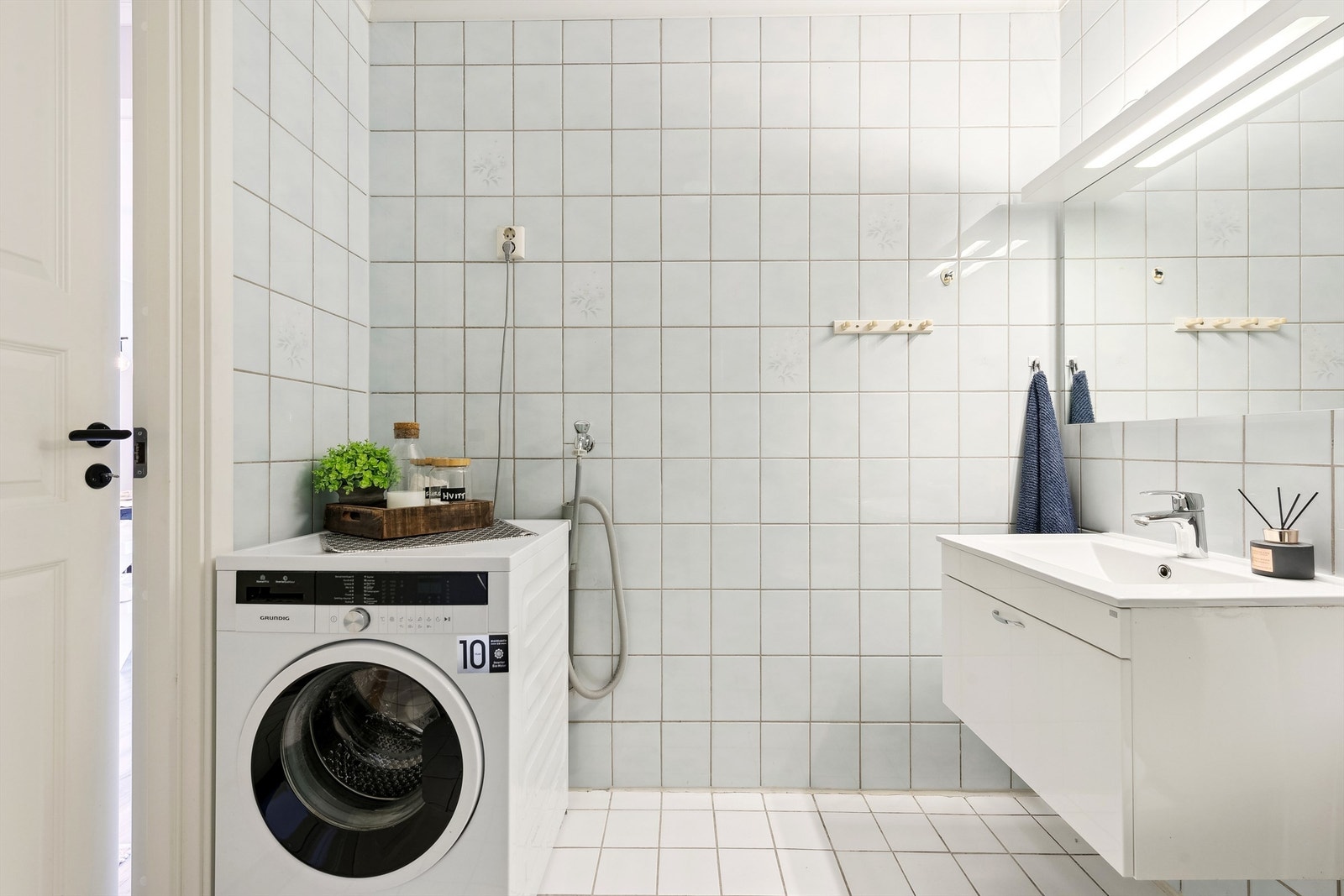 Lyst baderom med opplegg for vaskemaskin Galleribilde