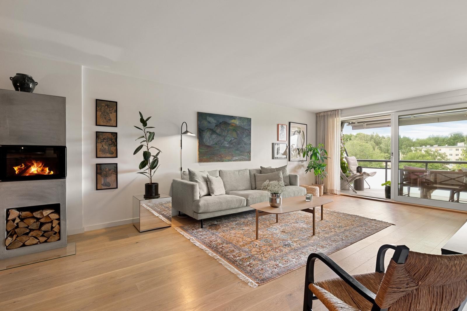 I allrommet er det en moderne og stilren peis med nisje for oppbevaring av ved Galleribilde
