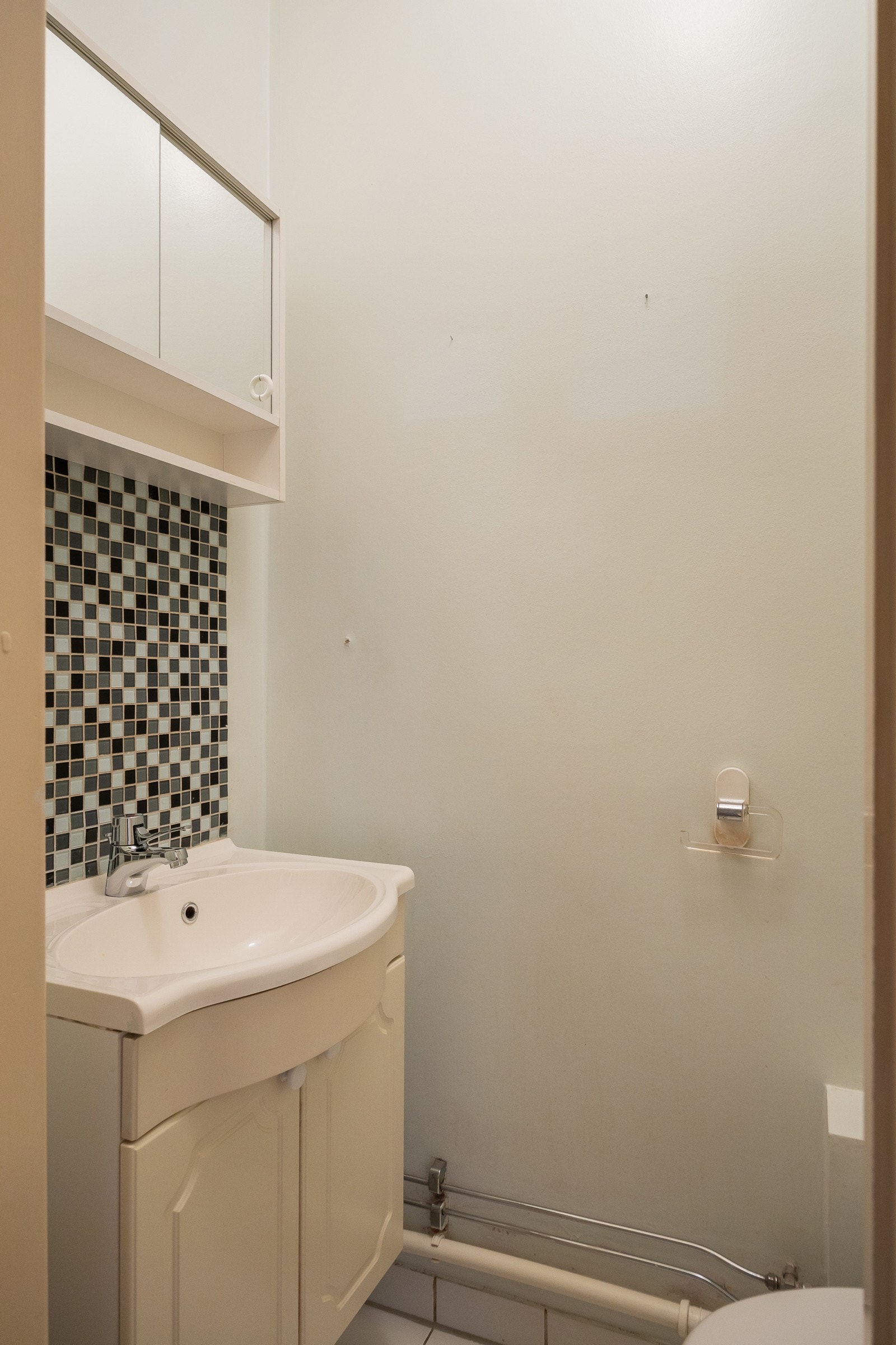 Separat toalettrom inneholder et toalett og servantskap med blandebatteri Galleribilde