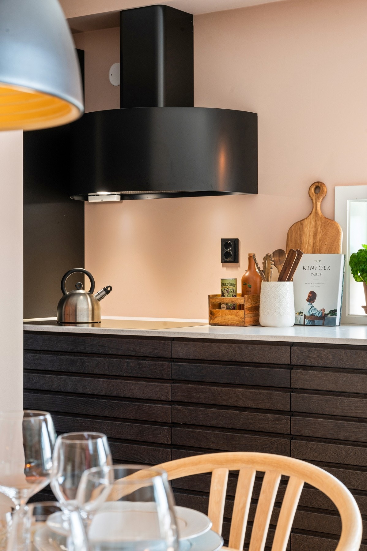 Løsningen kombinerer moderne design med høy kvalitet, og er utstyrt med mørke, matte skapfronter som skaper en flott kontrast mot de lyse steinbenkeplatene. Galleribilde