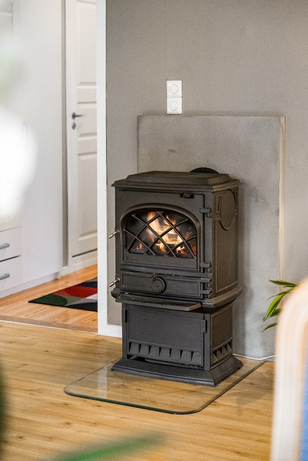 Midt i stuen finner du en flott og stilren peisovn som er både et vakkert blikkfang og en praktisk varmekilde på kjølige dager. Den er sentralt plassert og skaper en lun og hyggelig atmosfære i rommet. Galleribilde