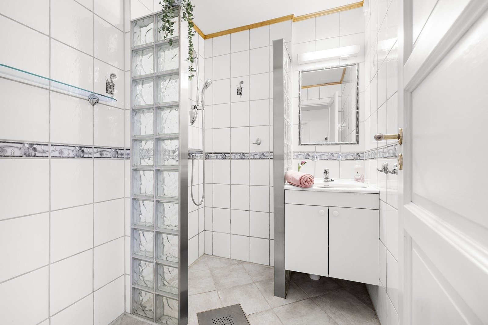 Eldre flislagt bad fra 2004. Rommet har innredning med nedfelt servant, speil med belysning over og dusjhjørne. Det er mekanisk avtrekk med tilluft under dørblad. Galleribilde