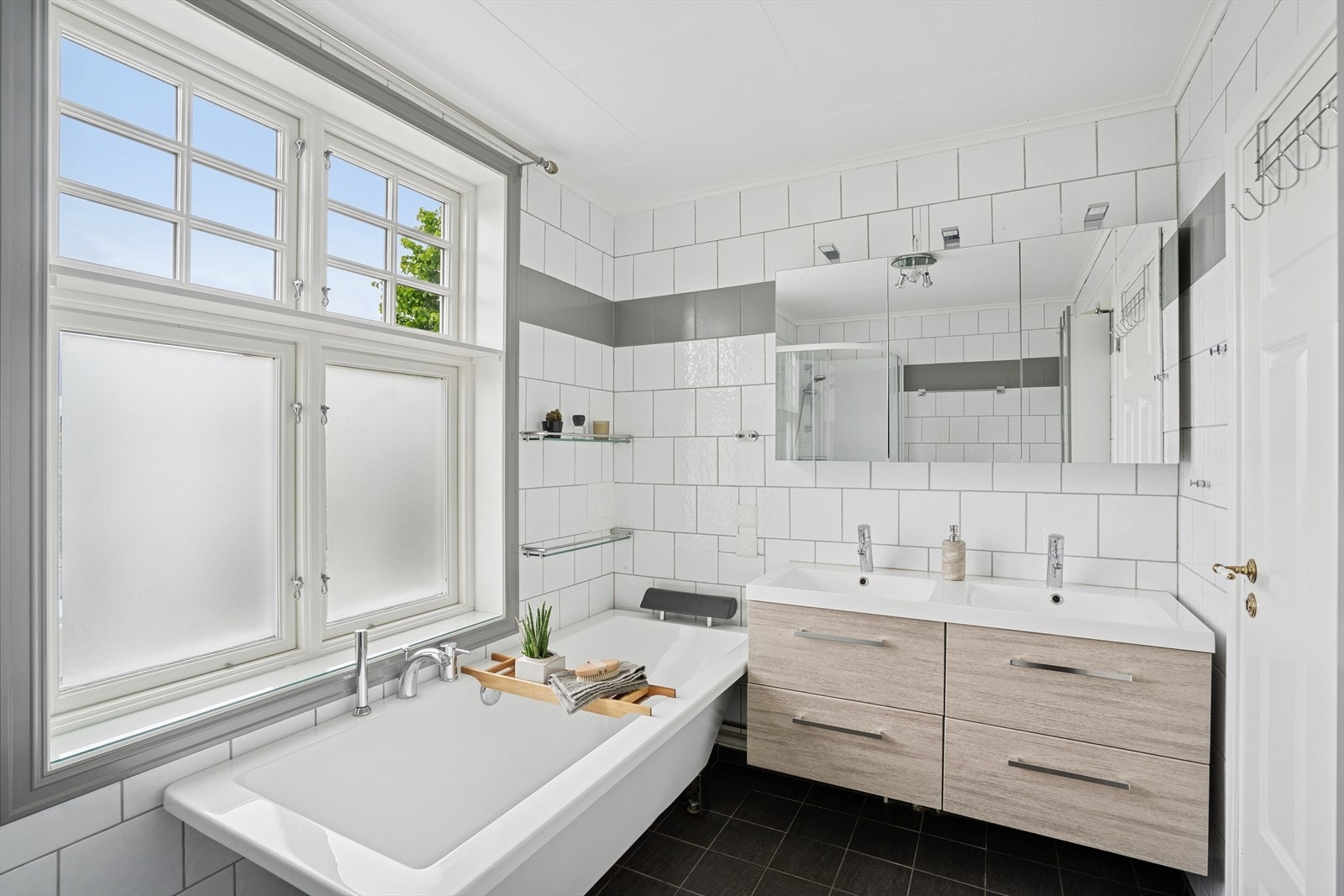 Baderomsinnredning med 2 nedfelte servanter, speilskap med overliggende belysning, toalett, dusjkabinett fra 2025 og et pent badekar med dusjarmatur Galleribilde