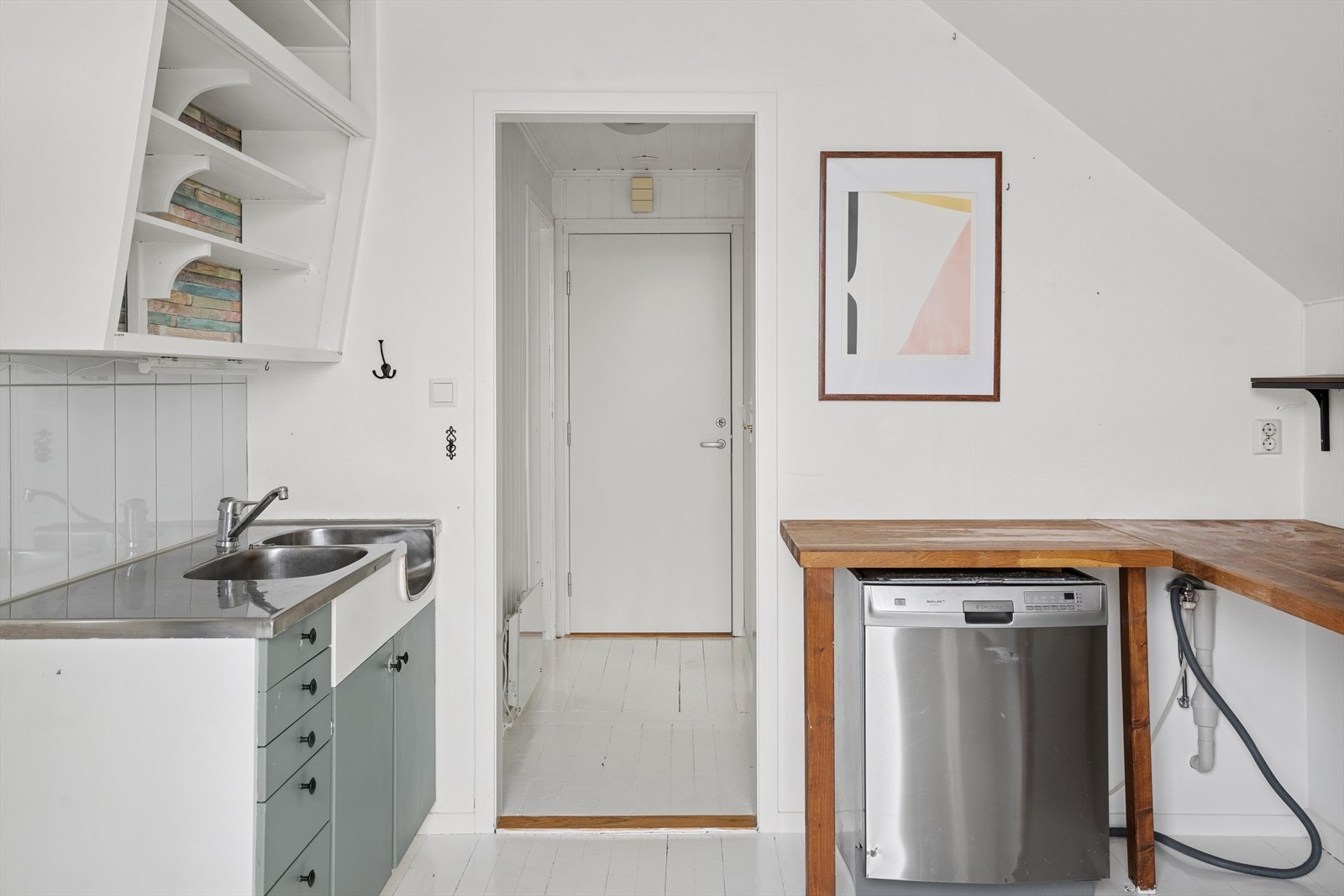 Kjøkkenet har innredning med glatte fronter og stål benk/oppvaskkum, samt en plassbygget benk av massivt tre. Galleribilde