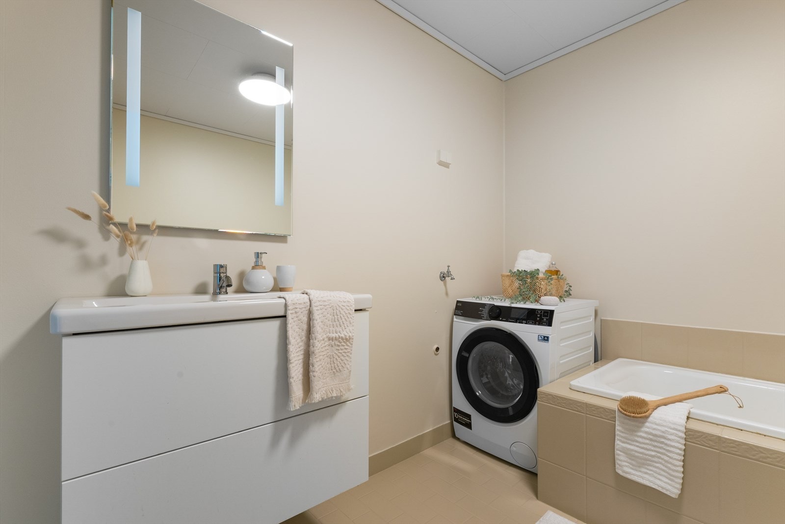 - Rommet måler 6,9 m² og er innredet med opplegg for vaskemaskin, innebygget badekar, gulvmontert toalett og benkeskap med servant - Galleribilde