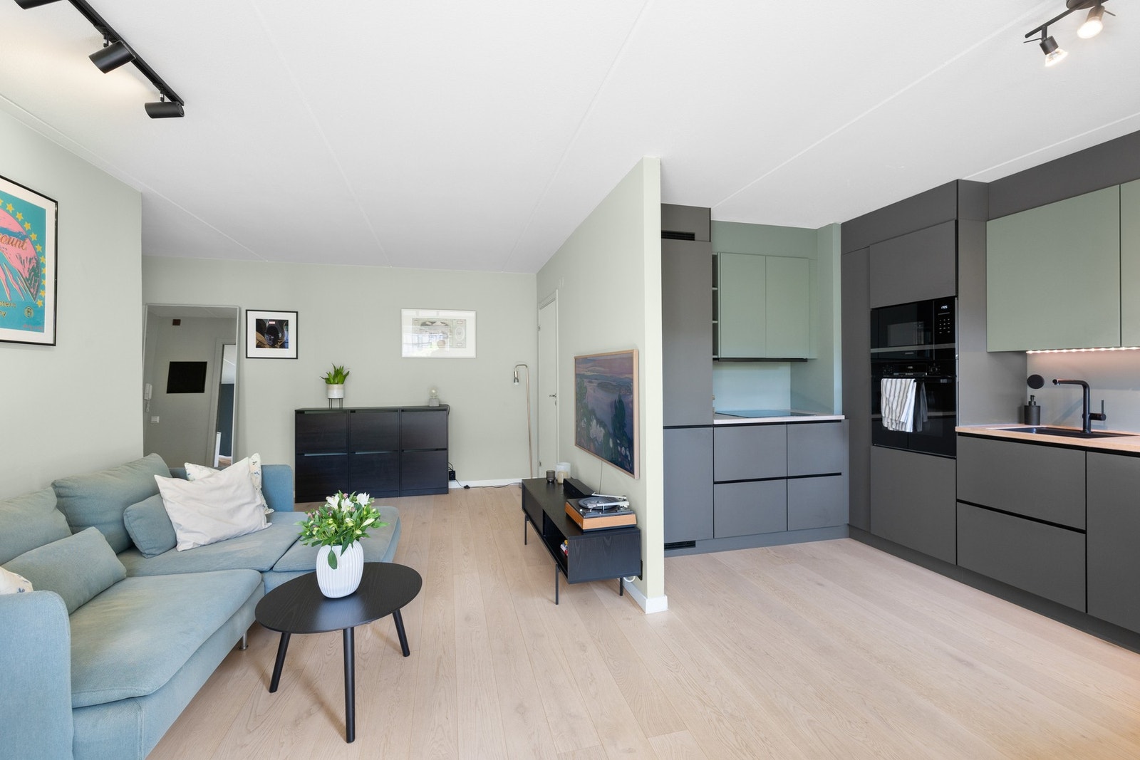 Moderne og innbydende stue med stilrene fargevalg og lekekr enstavs parkett på gulv. Galleribilde