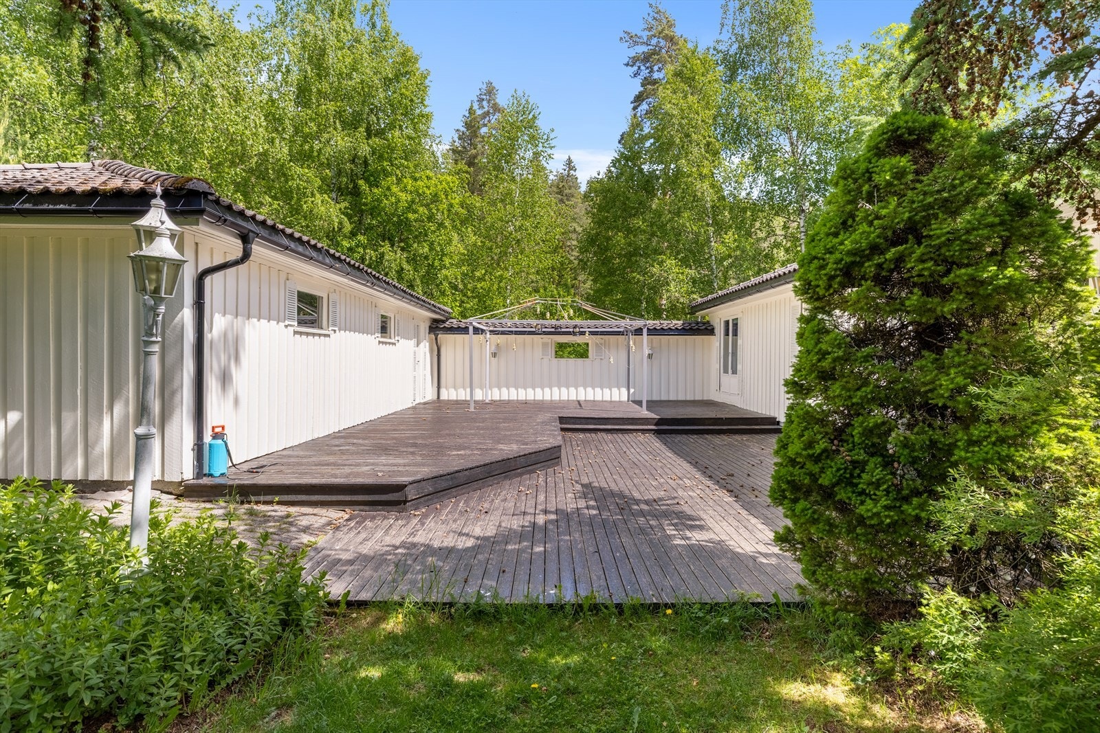 Romslig uteplass med stor terrasse - god plass til flere sittegrupper Galleribilde