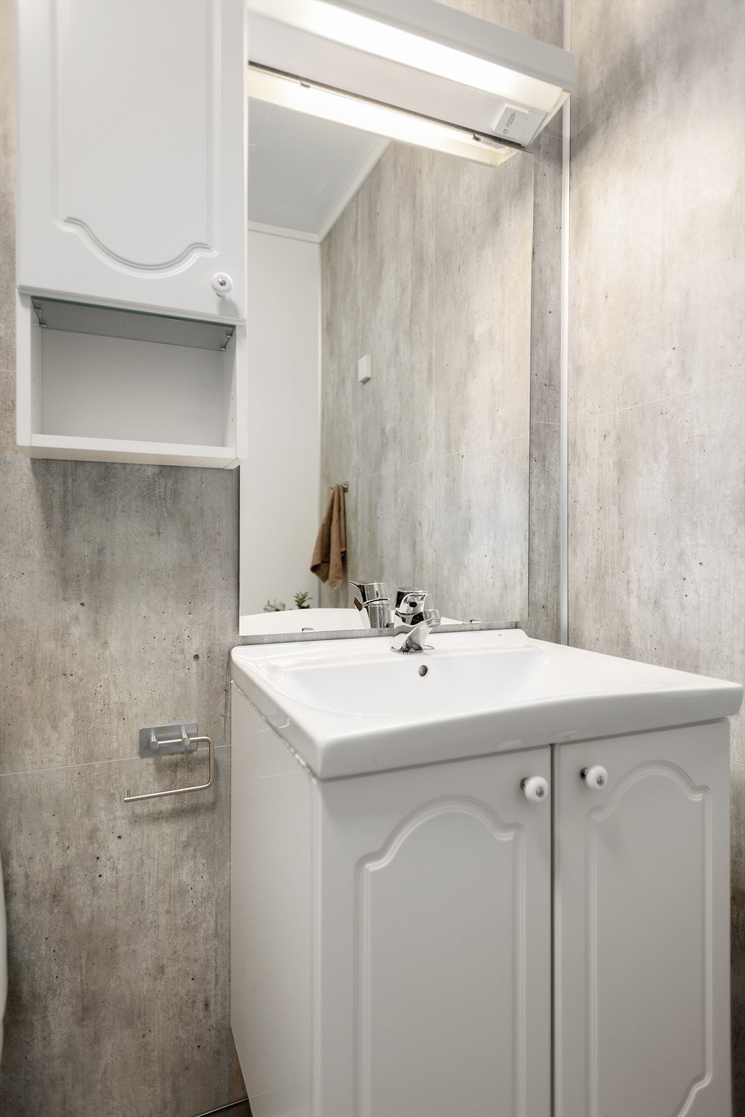 Badet har innredning med heldekkende servant og ett-greps blandebatteri, dusjkabinett, gulvmontert toalett og opplegg for vaskemaskin. Galleribilde