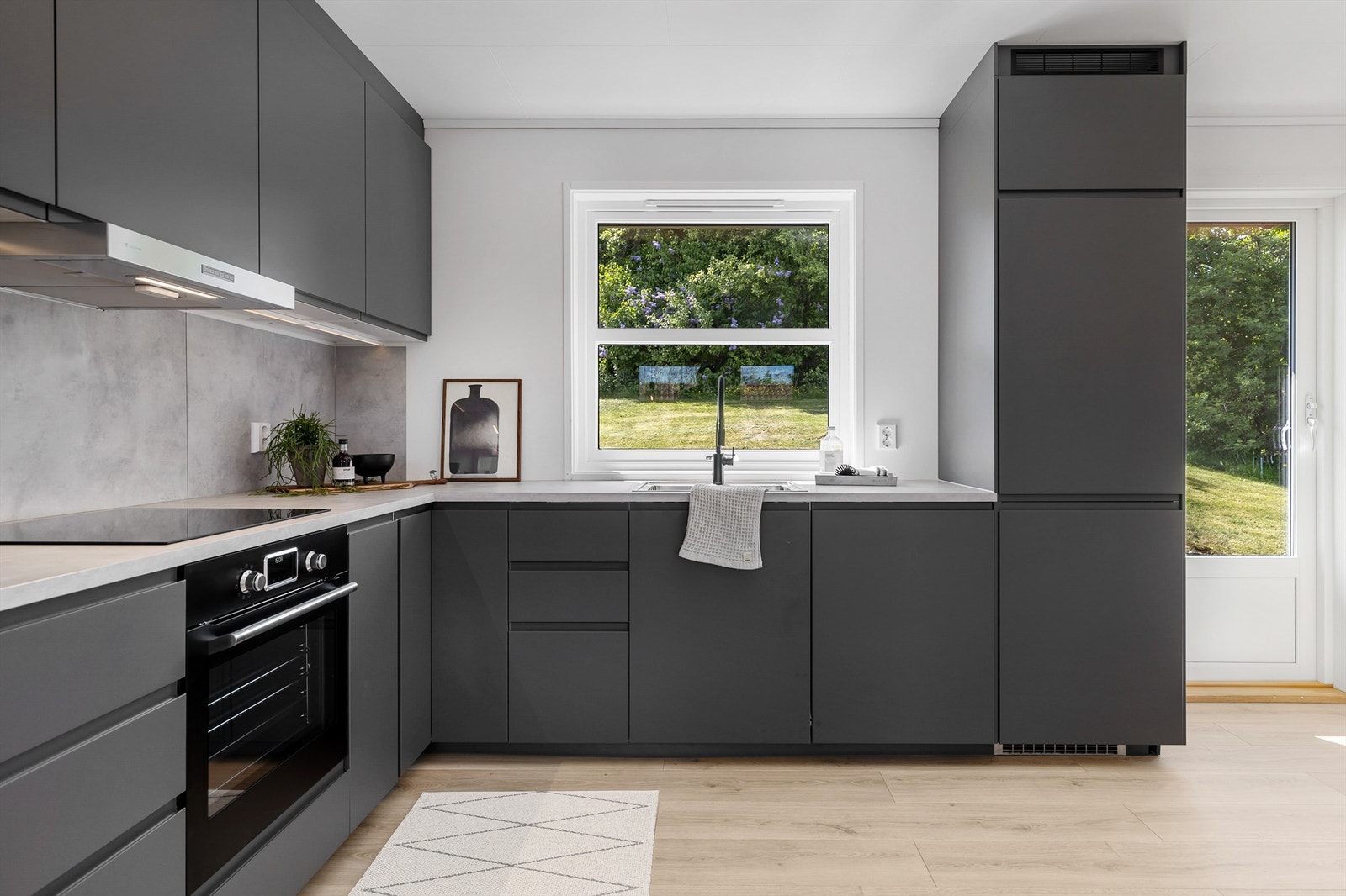 Integrerte hvitevarer som kjøleskap med frys, stekeovn med selvrens-funksjon, induksjon plate-topp, oppvaskmaskin. Galleribilde