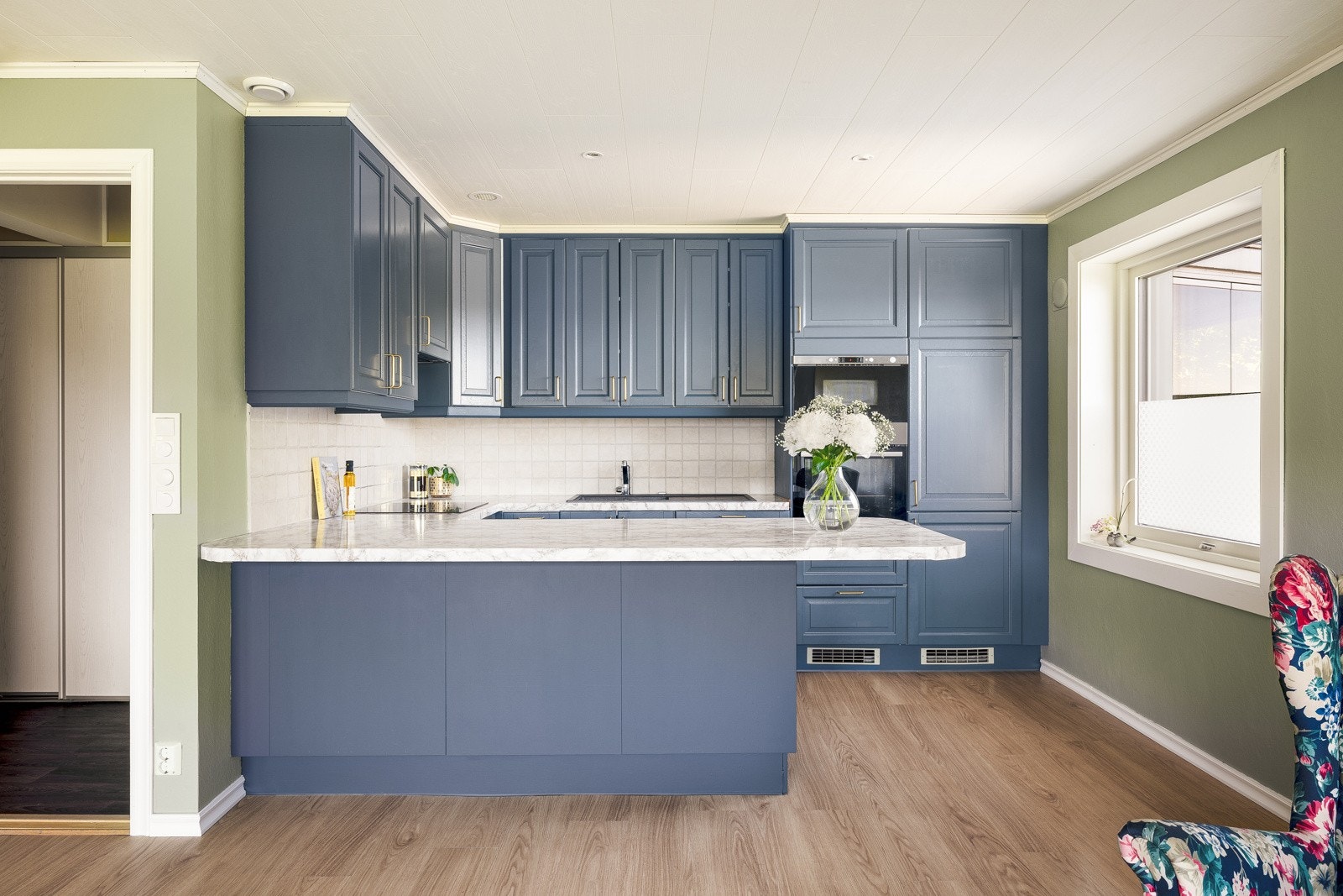 Kjøkkeninnredningen består av malte fronter og laminat benkeplate med nedfelt vask. Galleribilde