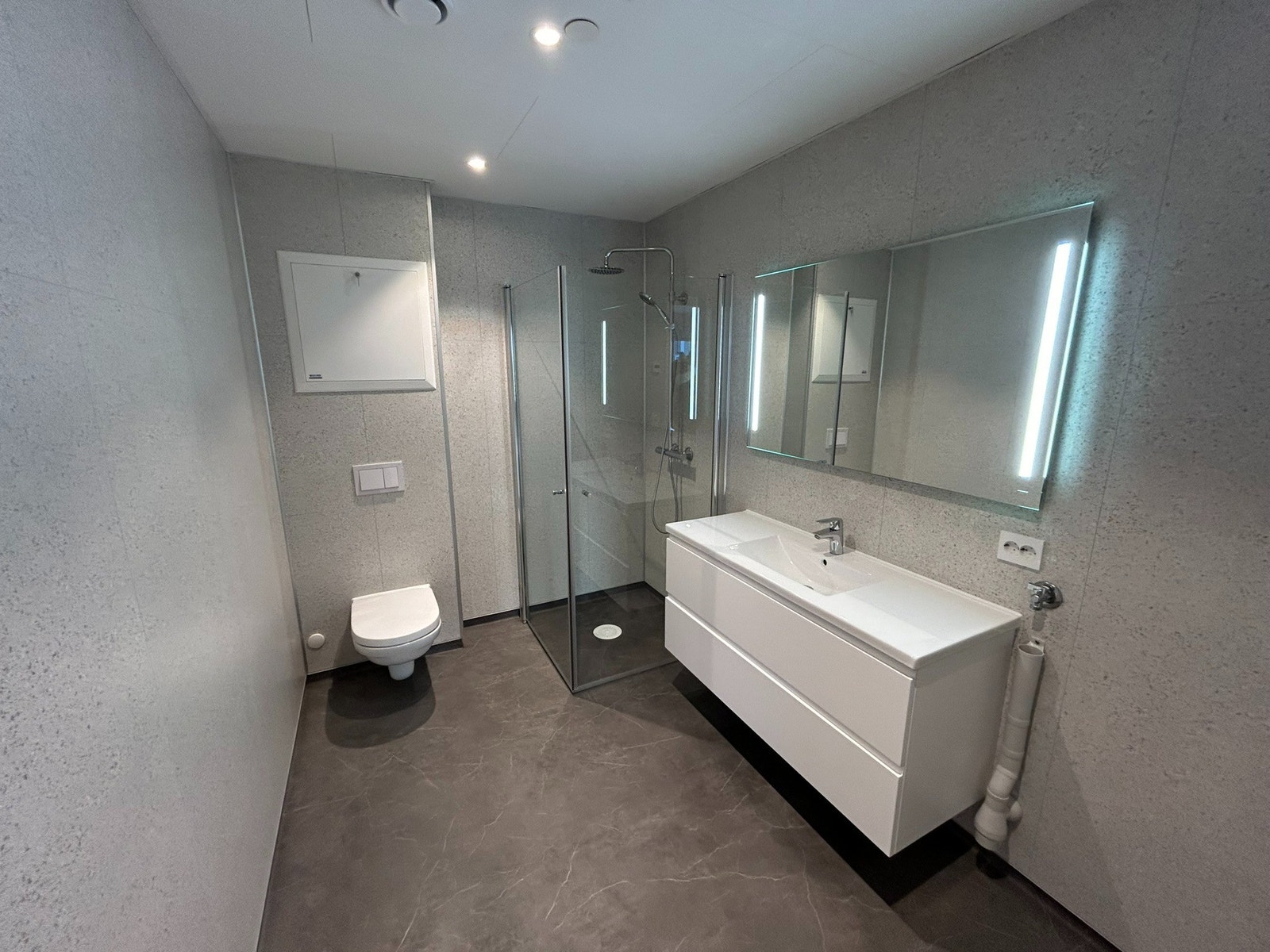 Bad med toalett og dusj og tilkobling for vaskemaskin Galleribilde