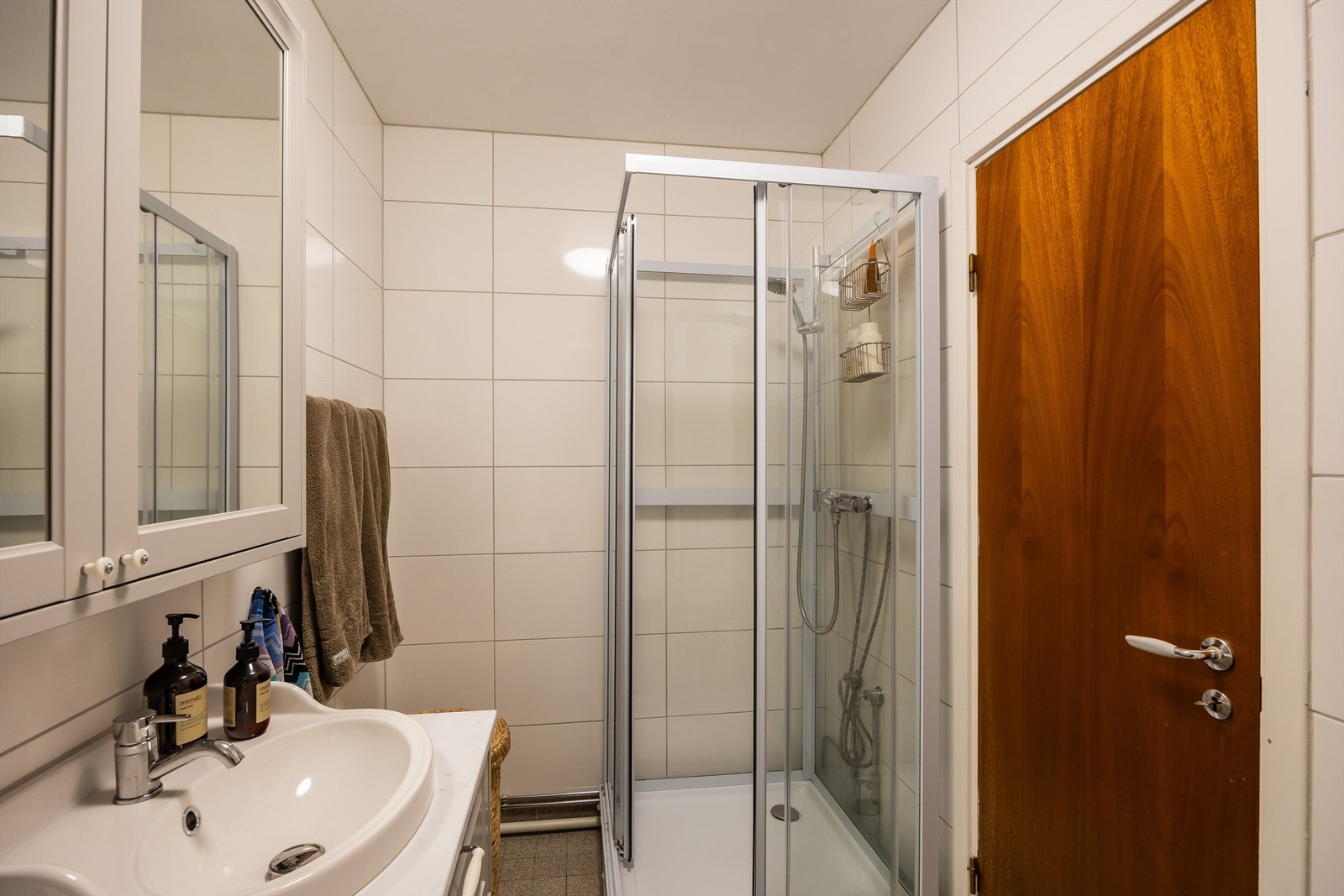 Baderommet har sluk fra byggeår, men er oppgradert med fliser på vegger og servantskap i 2024. Badekar er byttet ut med dusjkabinett - en funksjonell og trygg løsning på eldre bad. Galleribilde