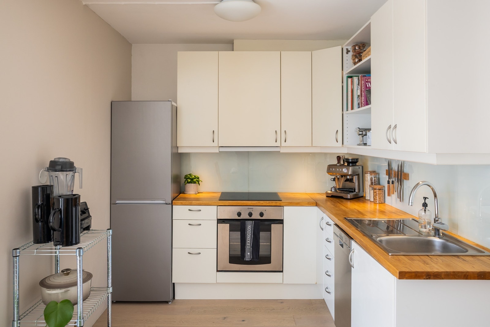 Kjøkkeninnredningen fra 2006 har slette, moderne fronter og benkeplater i tre som tilfører rommet et varmt uttrykk. Hvitevarer medfølger: integrert stekeovn med nedfelt platetopp, samt frittstående oppvaskmaskin og kombinert kjøl-/fryseskap. Galleribilde