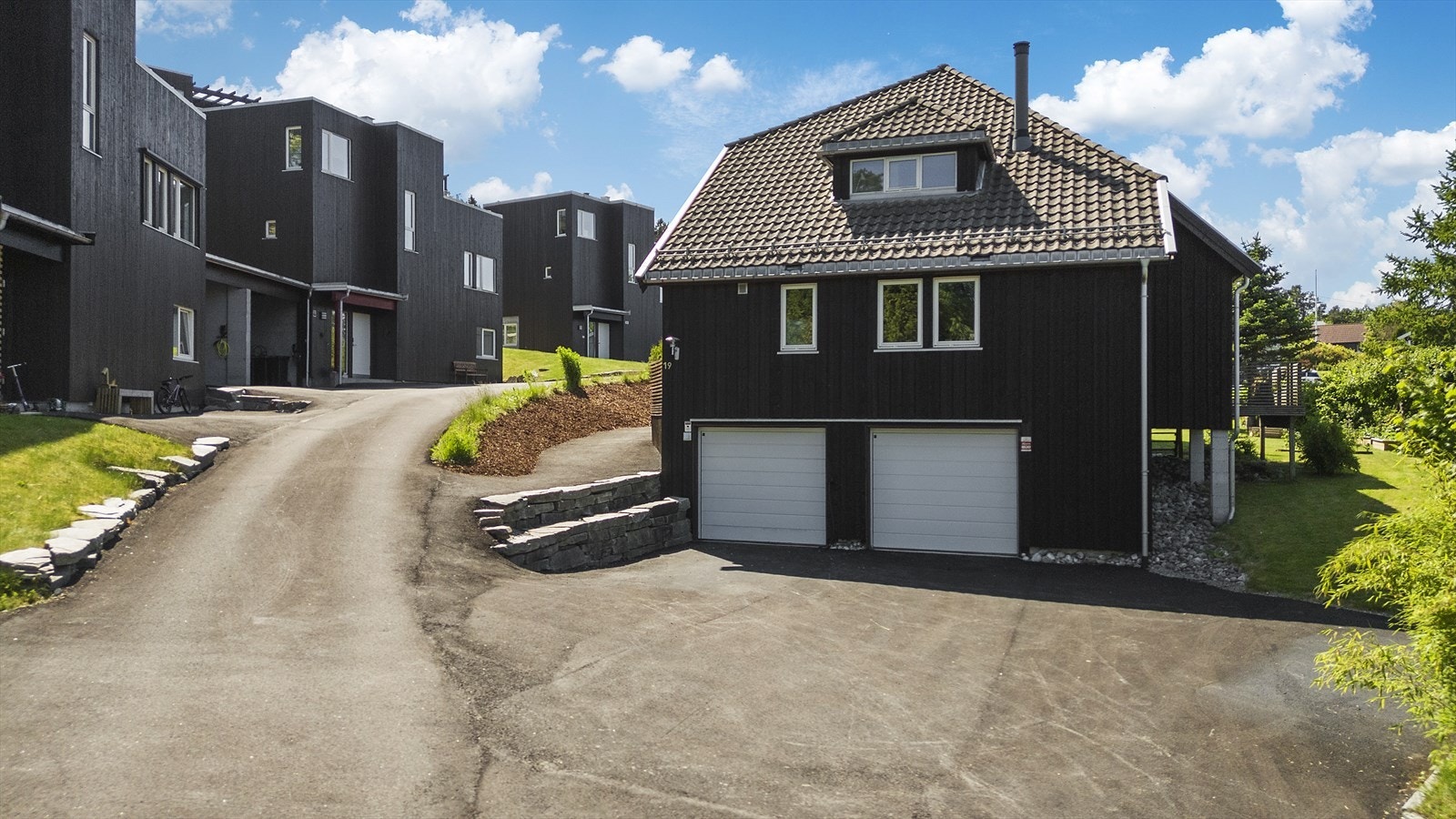 Parkering i garasje og gårdsplass. Det er montert Tesla vegglader Galleribilde