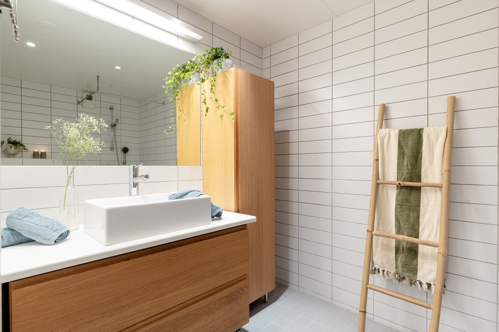 Badet er utstyrt med innredning med nedfelt servant, vegghengt toalett og dusjvegger/hjørne. Galleribilde