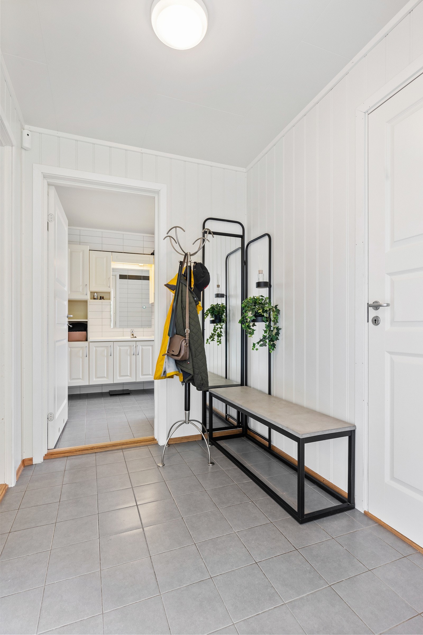 Velkommen inn. Boligen tar oss varmt i mot med en romslig entré med flislagt gulv med varmekabler. Galleribilde