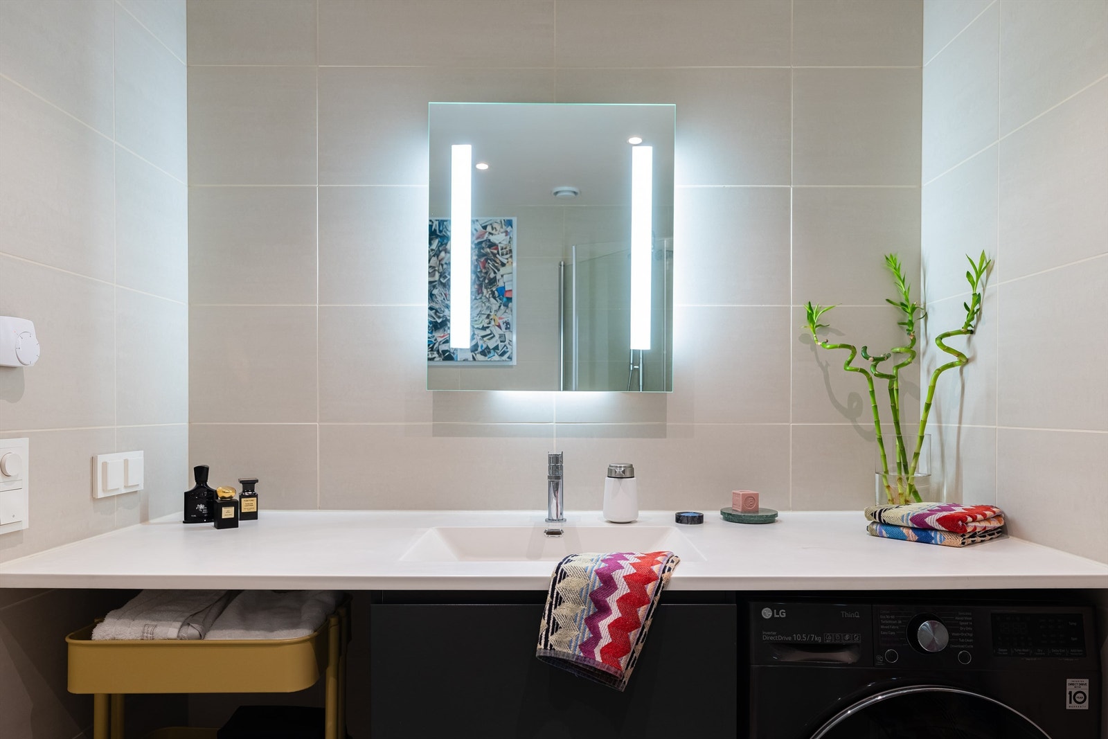 Over servanten er det et fint speil med innebygget belysning. Det er opplegg for vaskemaskin. Galleribilde