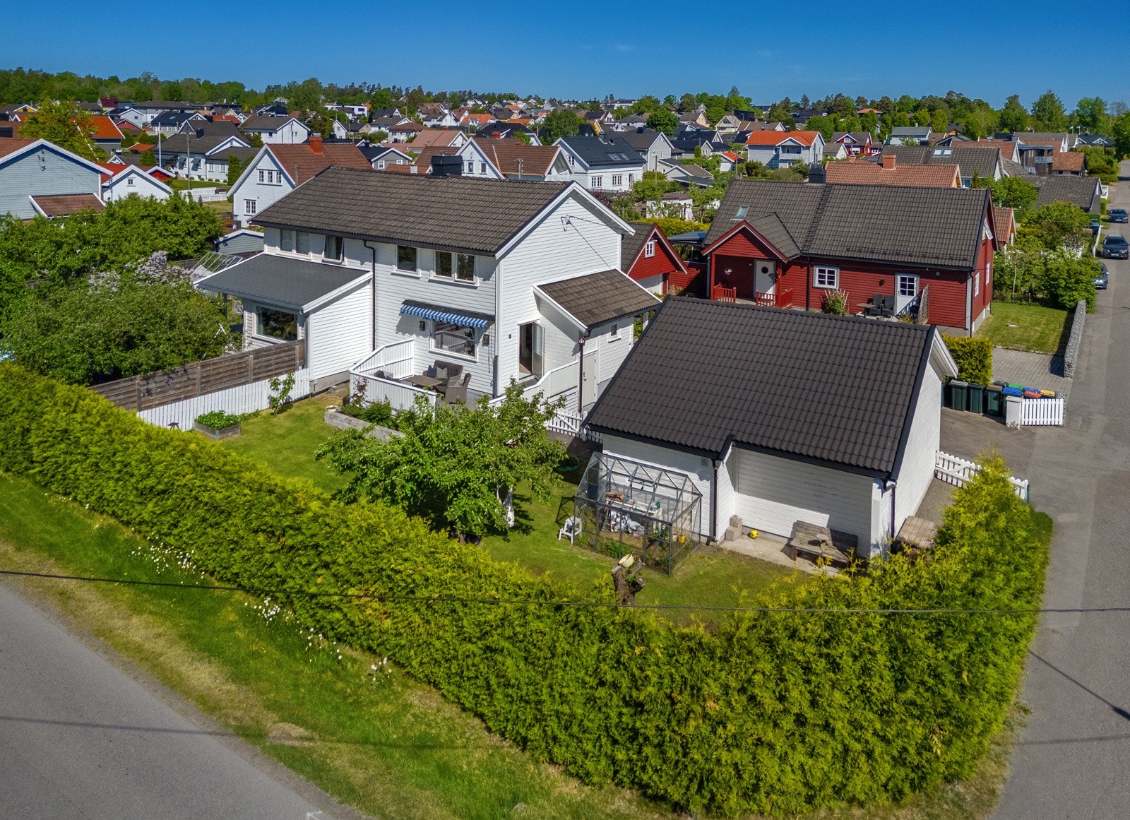 Eiendommen sett fra syd - bestående en av halvpart av tomannsbolig, samt en hel dobbelgarasje fra 2015 Galleribilde
