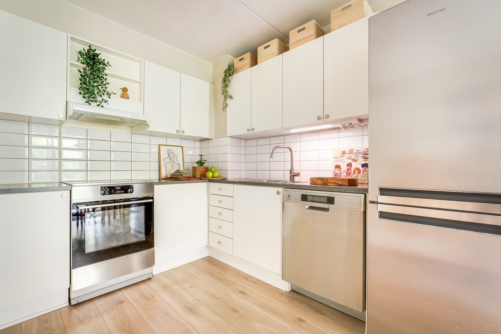 Kjøkkeninnredning med lyse, slette fronter og benkeplate av laminat med nedfelt oppvaskkum. Galleribilde