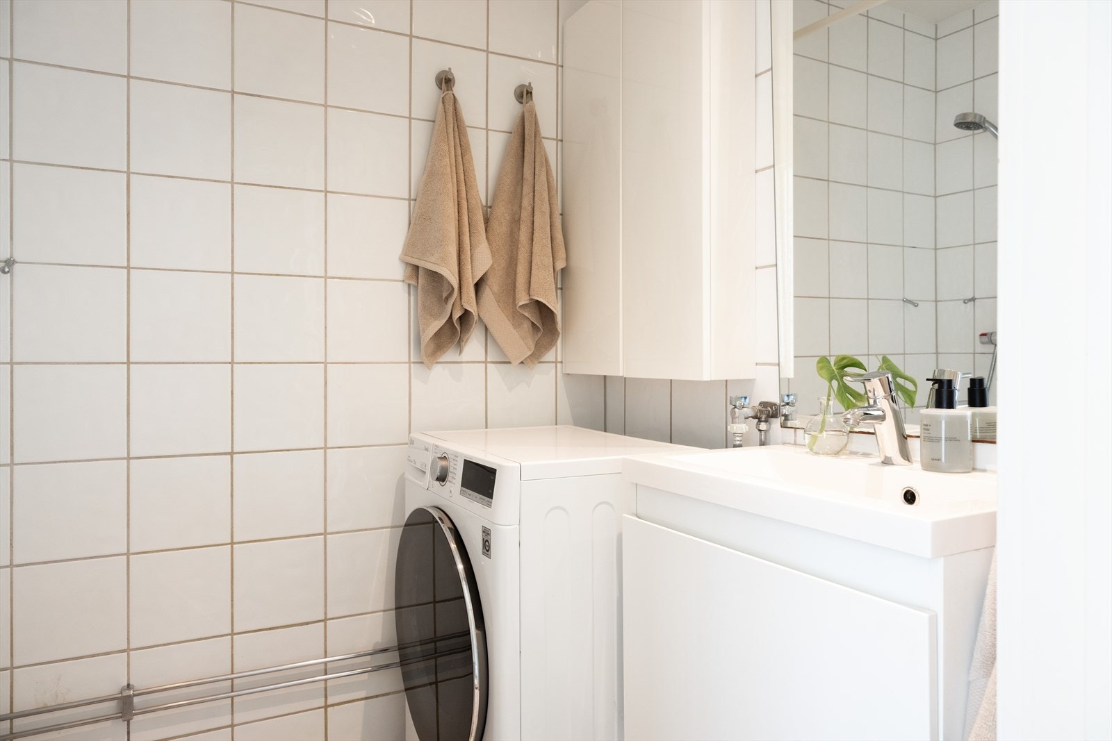 Badet er innredet med klosett, servant nedfelt i innredning, speil m/lys og dusjhjørne med forheng. Videre er det opplegg for vaskemaskin. Galleribilde