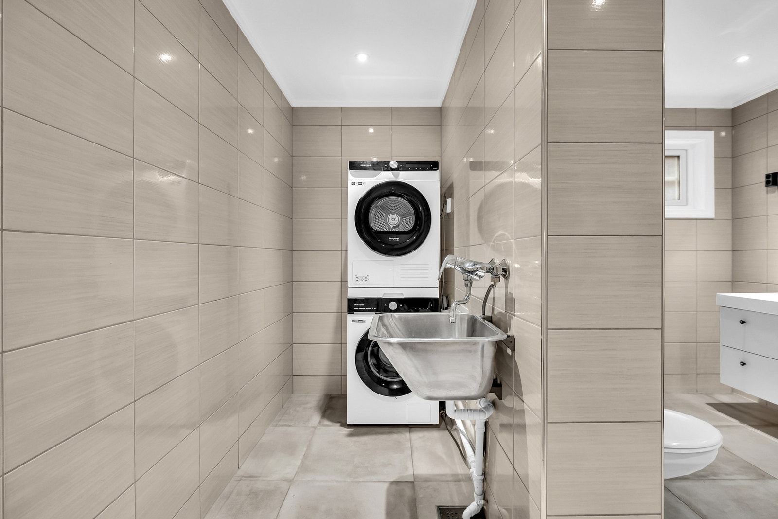 Her er det opplegg for vaskemaskin og tørketrommel. Praktisk utslagsvask. Galleribilde