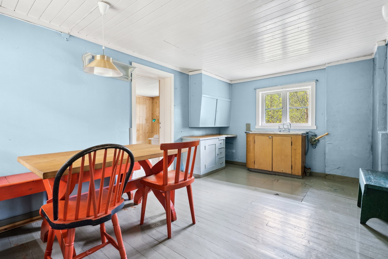 Eldre kjøkkeninnrending med glatte fronter. Bekeplaten er av tre og tildekt med voksduk. Det er oppvaskbenkt i stål med nedfelt kum. Galleribilde