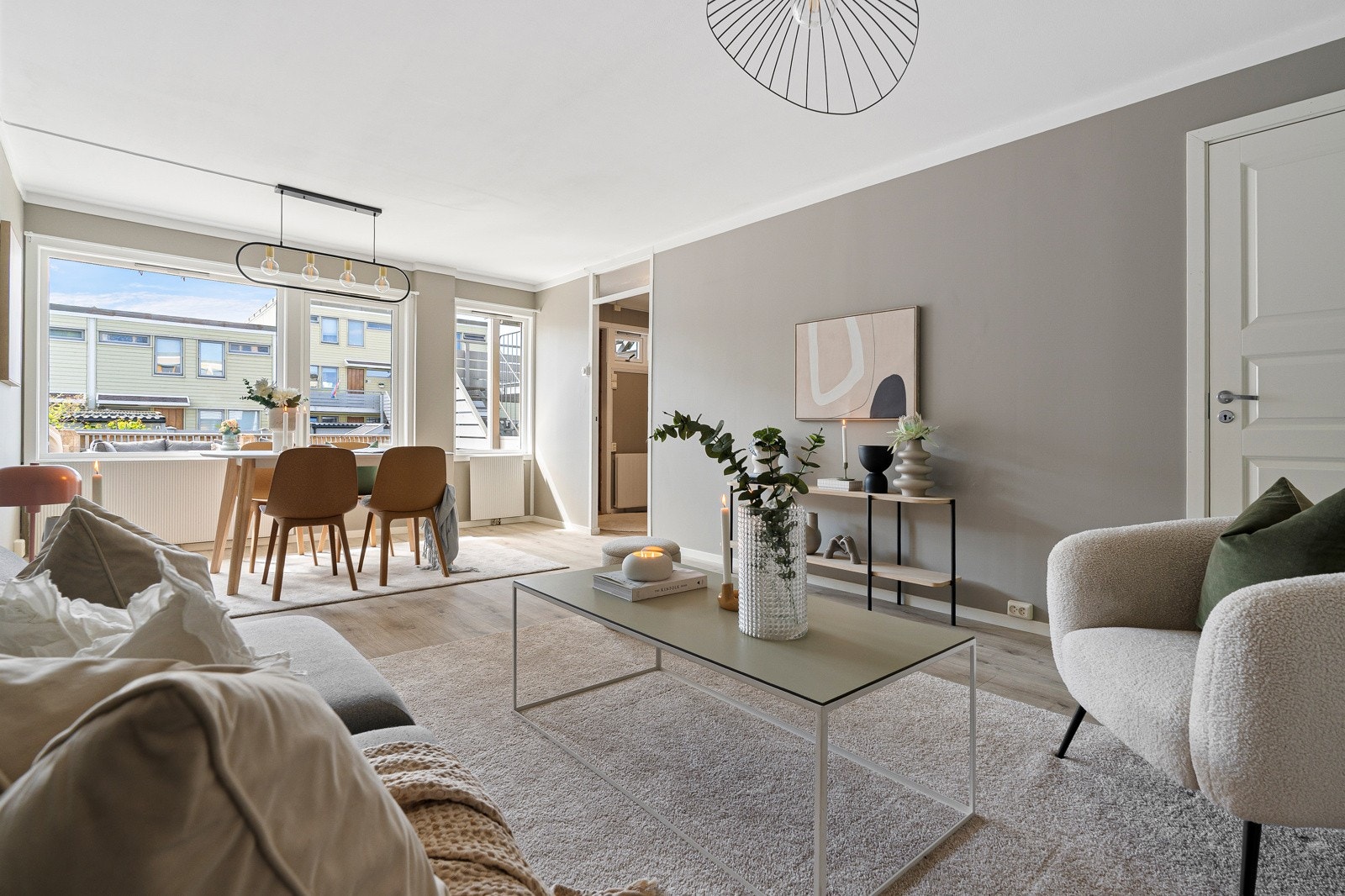 Stuen fremstår innbydende med nøytrale fargevalg på vegger, 1-stavs gulv og mye naturlig dagslys fra store vindu. Galleribilde