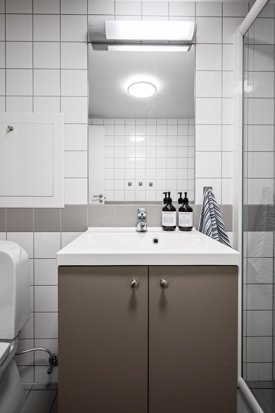 Innredningen består av servant nedfelt i innredning, speil over servant, toalett og dusjhjørne med skyvedører. Det er opplegg for vaskemaskin og mekanisk avtrekk. Galleribilde