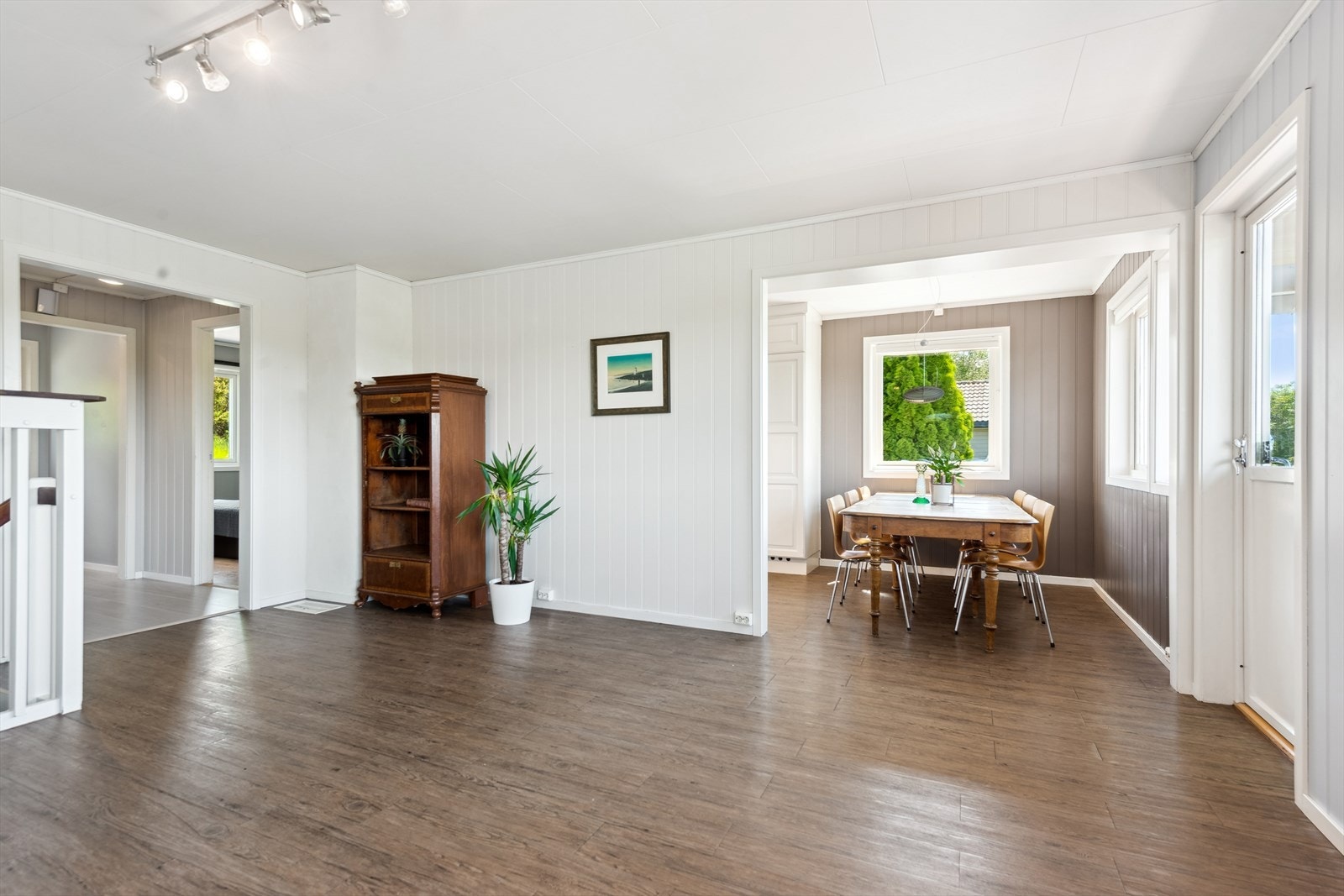 Den åpne løsningen mot kjøkkenet skaper en luftig og sosial atmosfære, ideell for moderne familieliv. Galleribilde