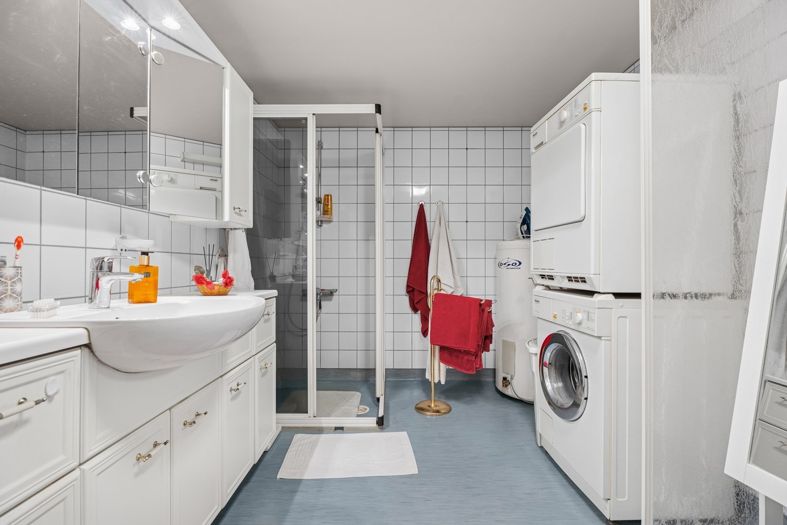 Stort baderom med servant i skapinnredning, dusj, toalett og opplegg til vaskemaskin m.m. Galleribilde