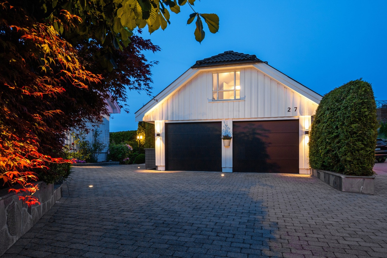 Det er parkering i en frittliggende dobbelgarasje og på en steinbelagt gårdsplass. Galleribilde