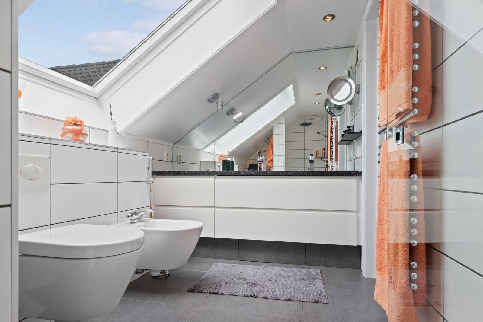 Baderomsinnredningen har hvite fronter og består av en heldekkende servant på en skuffeseksjon og et stort speil med god belysning. Galleribilde