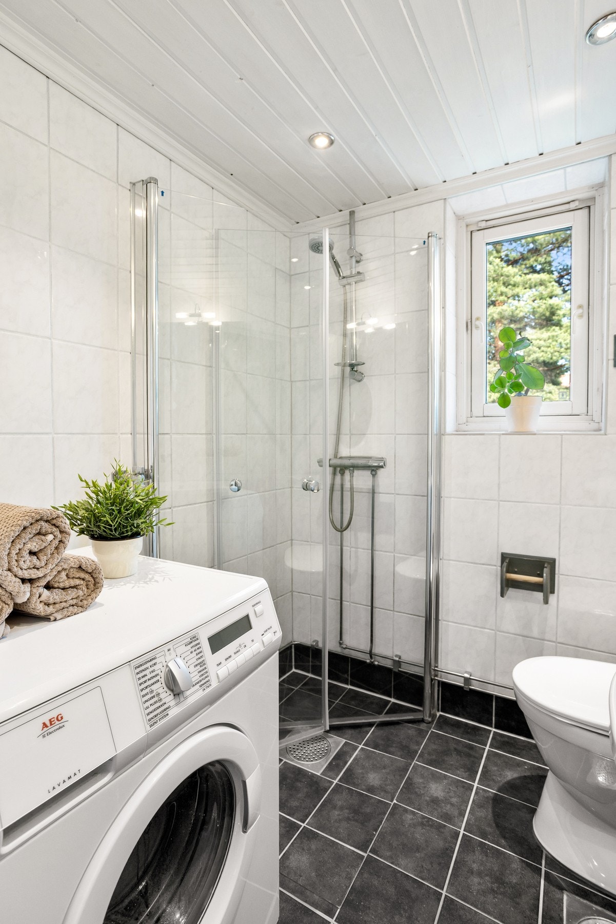 Her er det gulvstående toalett, dusjhjørne med svingbare dører som frigjør plass på gulvet og opplegg for vaskemaskin. Galleribilde