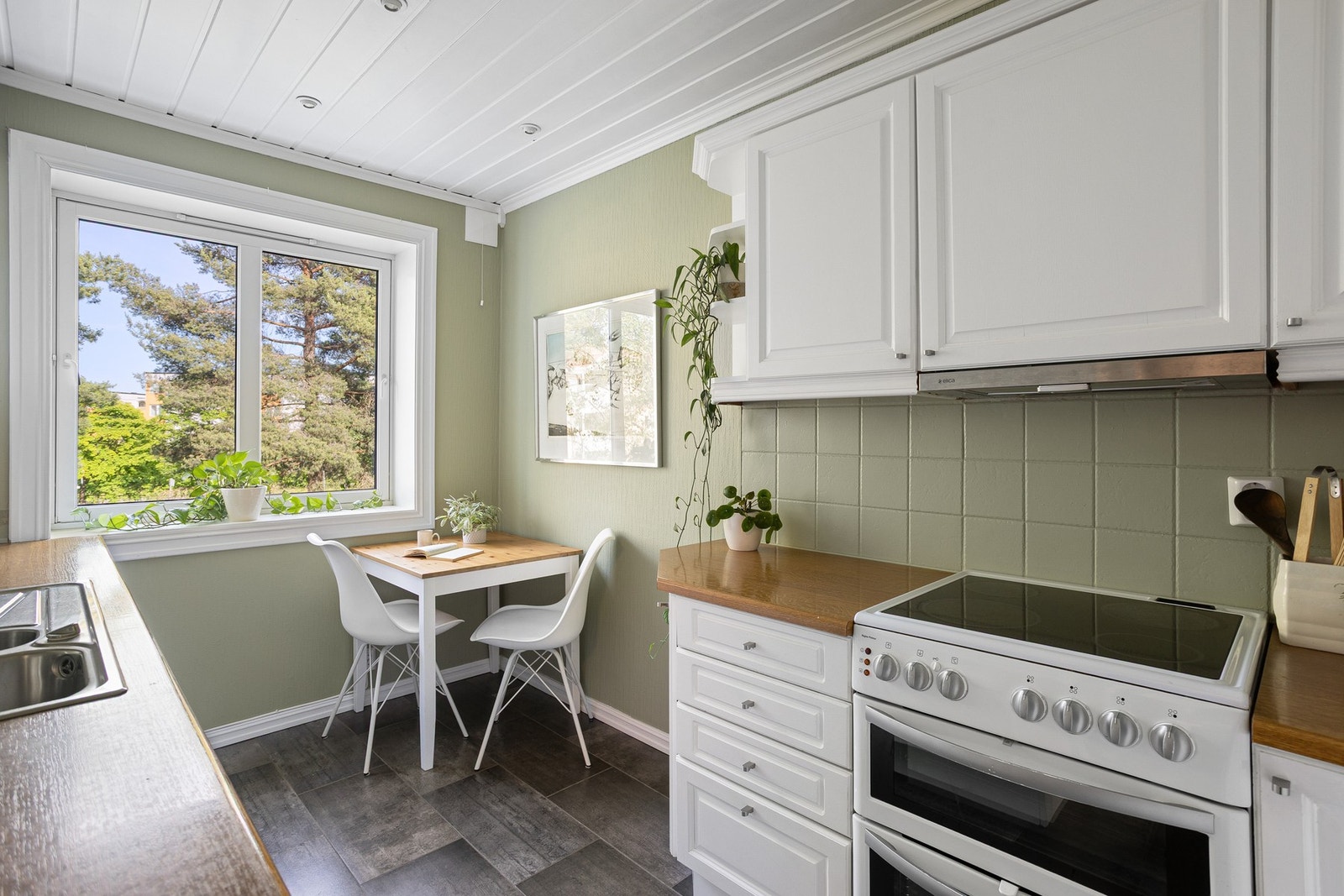 Lys, profilert innredning med laminat benkeplate og nedfelt stålvask med ettgreps-blandebatteri. Galleribilde