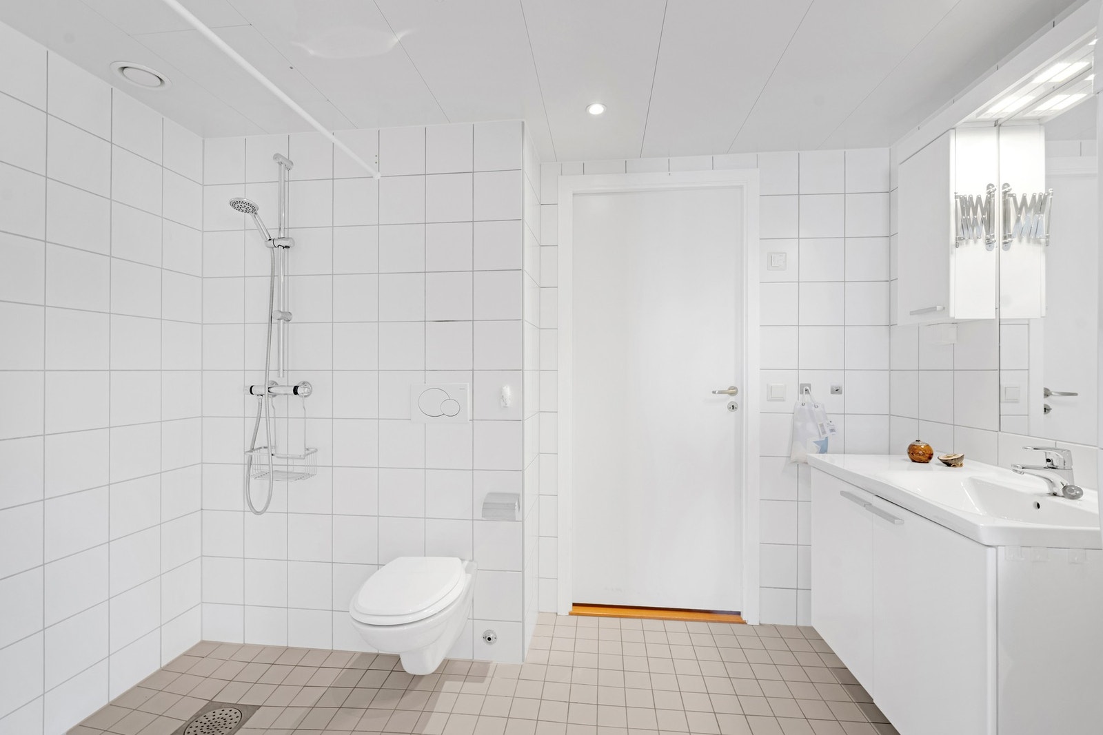 Stort bad med flislagte vegger og gulv med gulvvarme Galleribilde
