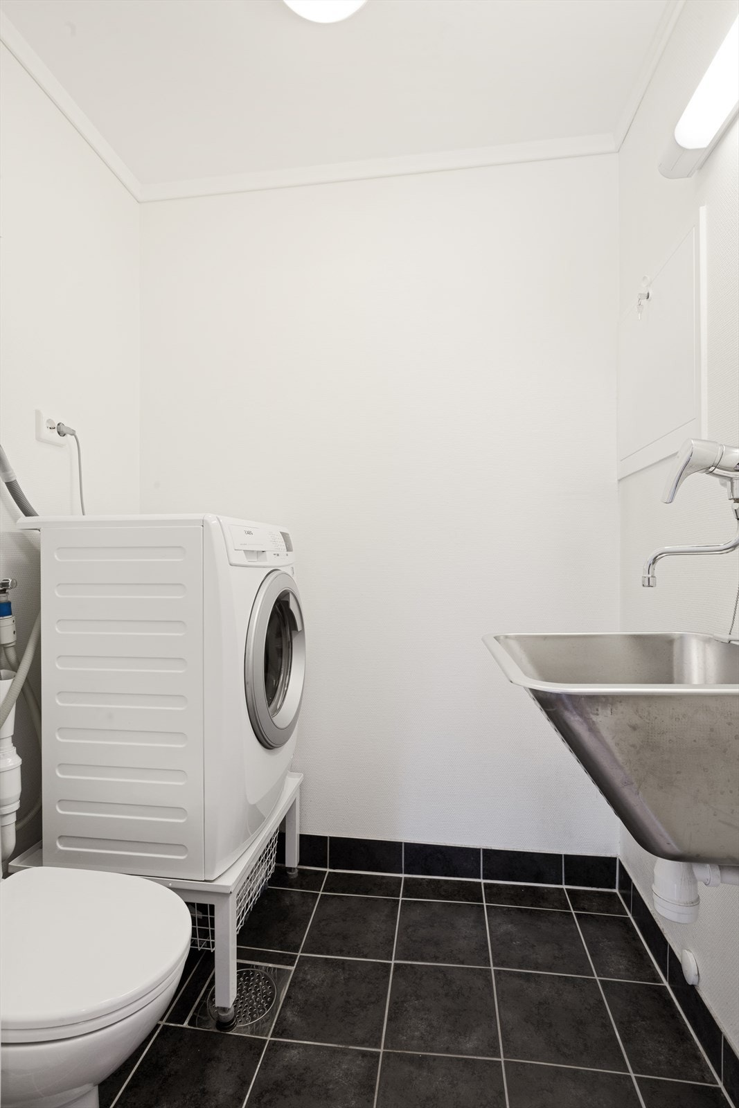 Vaskerom/wc med fliser på gulv med varmekabler og malt tapet på vegger Galleribilde