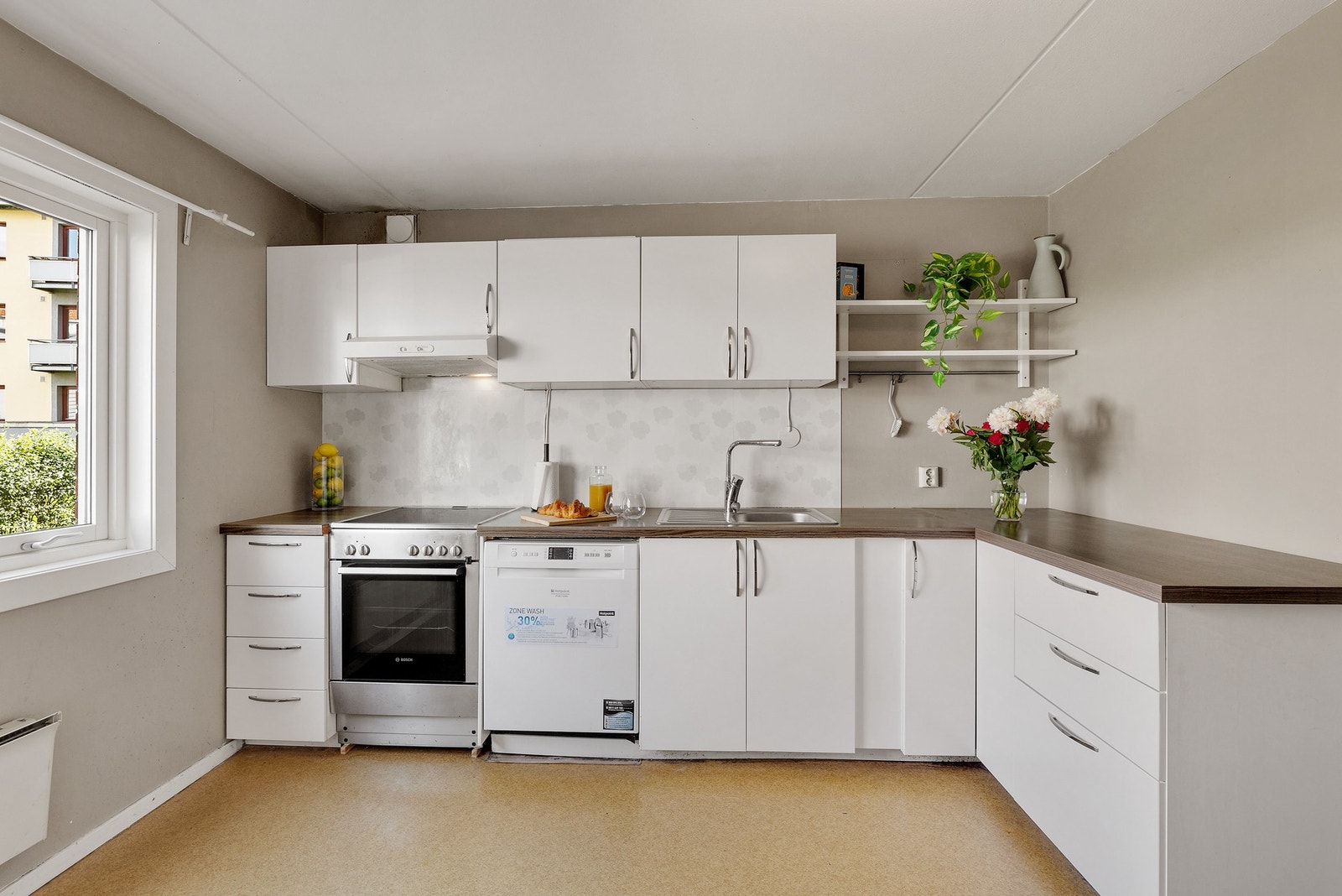 Hvit kjøkkeninnredning med god benkeplass. Galleribilde