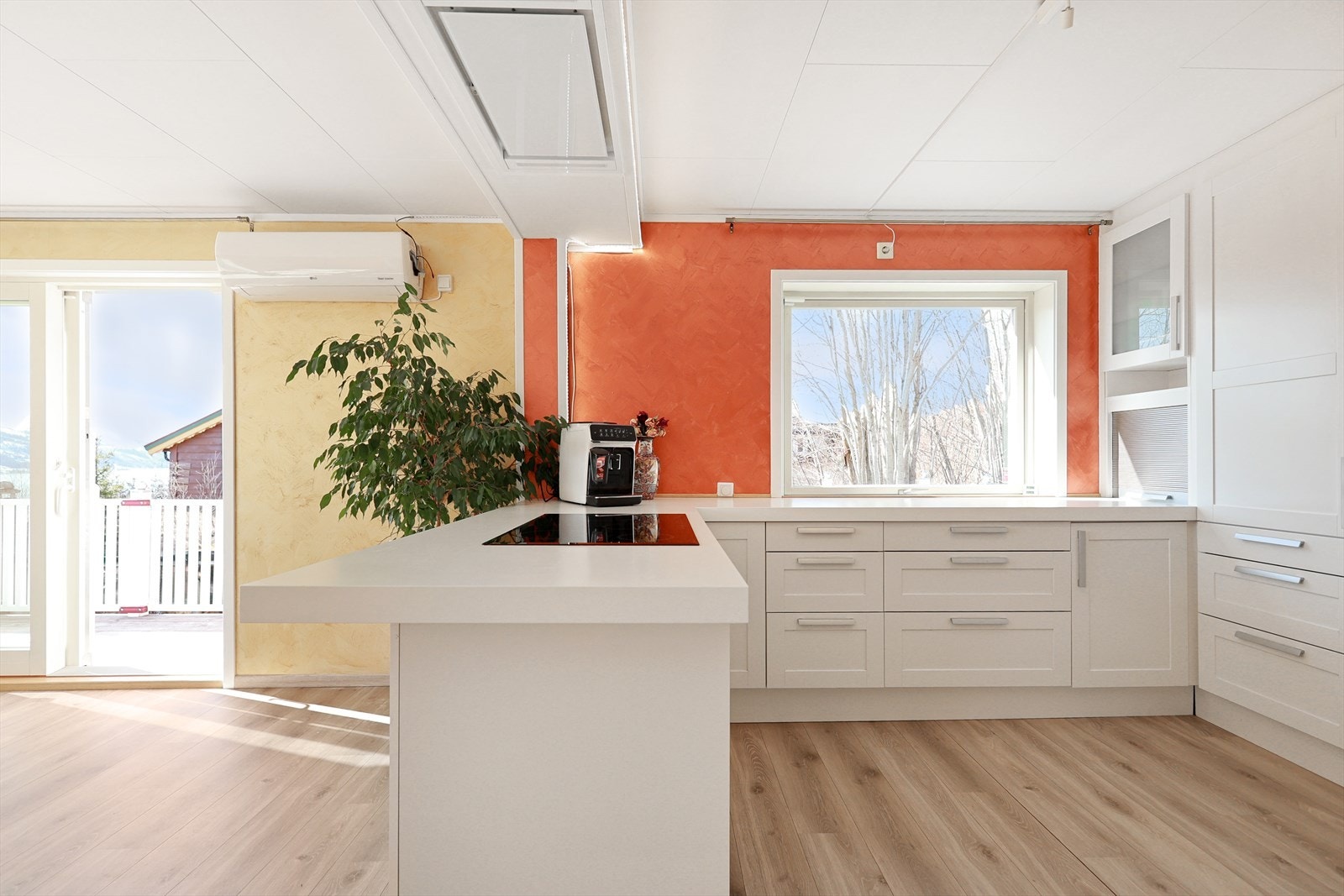 Stort, pent og innholdsrikt kjøkken med integrerte hvitevarer. Legg merke til ventilator som er innfelt i himling over koketopp. Galleribilde