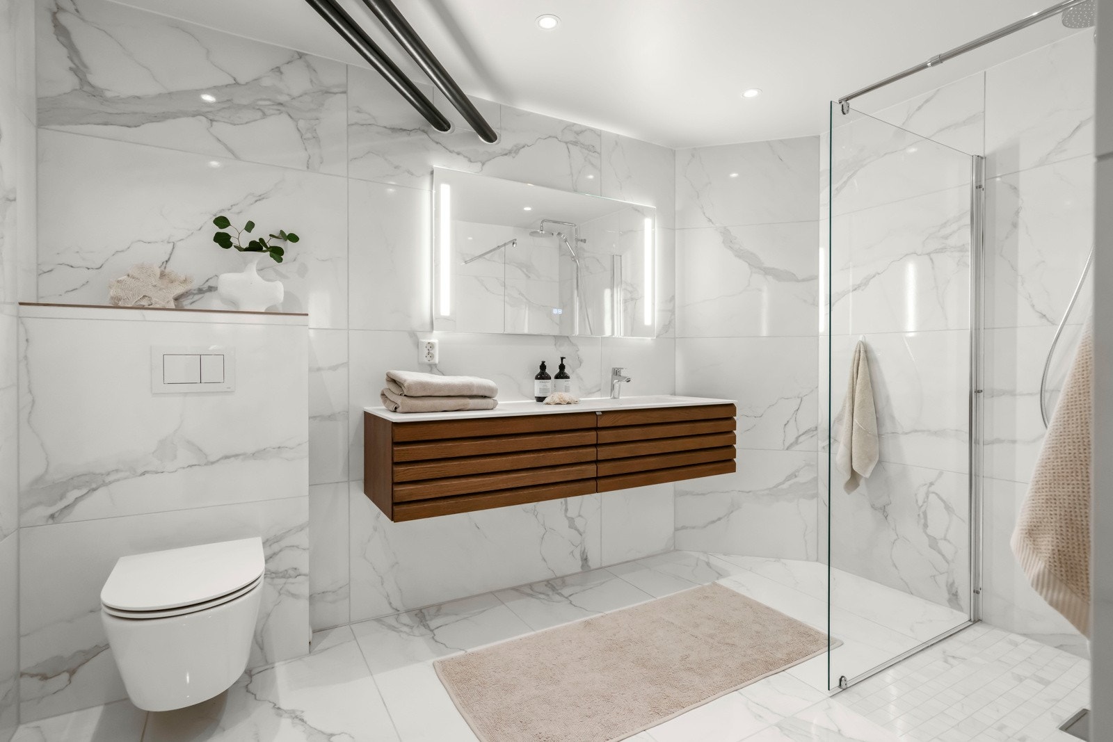 Boligen har 2 lekre nybygde bad med stilige Porcellanato-fliser i 120 x 60 cm på vegg og gulv, varmekabler. Regnfalls og håndholdt dusj. Egen nisje til vaskemaskin. Galleribilde