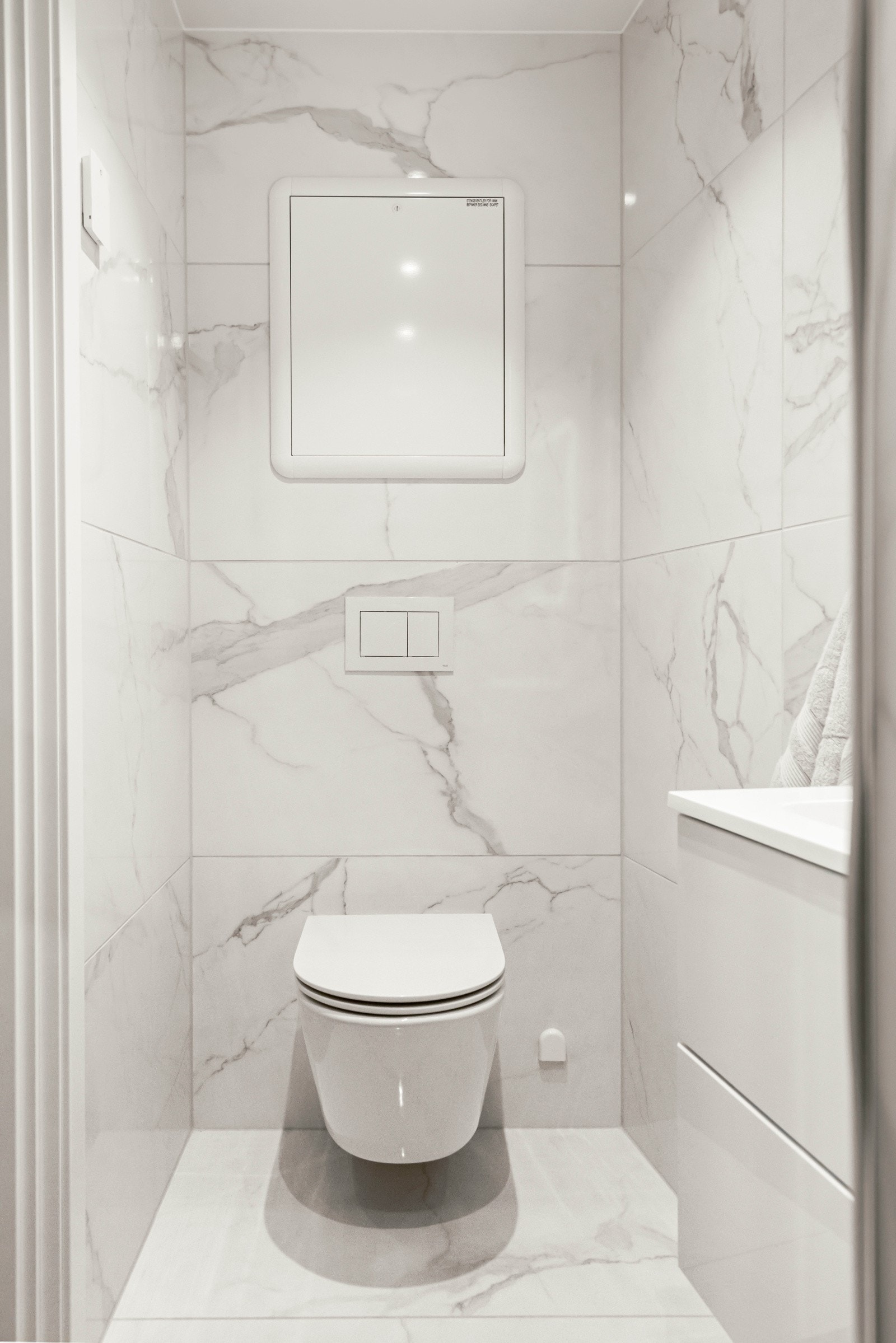 Badet har veggmontert wc med skjult sisterne. Galleribilde