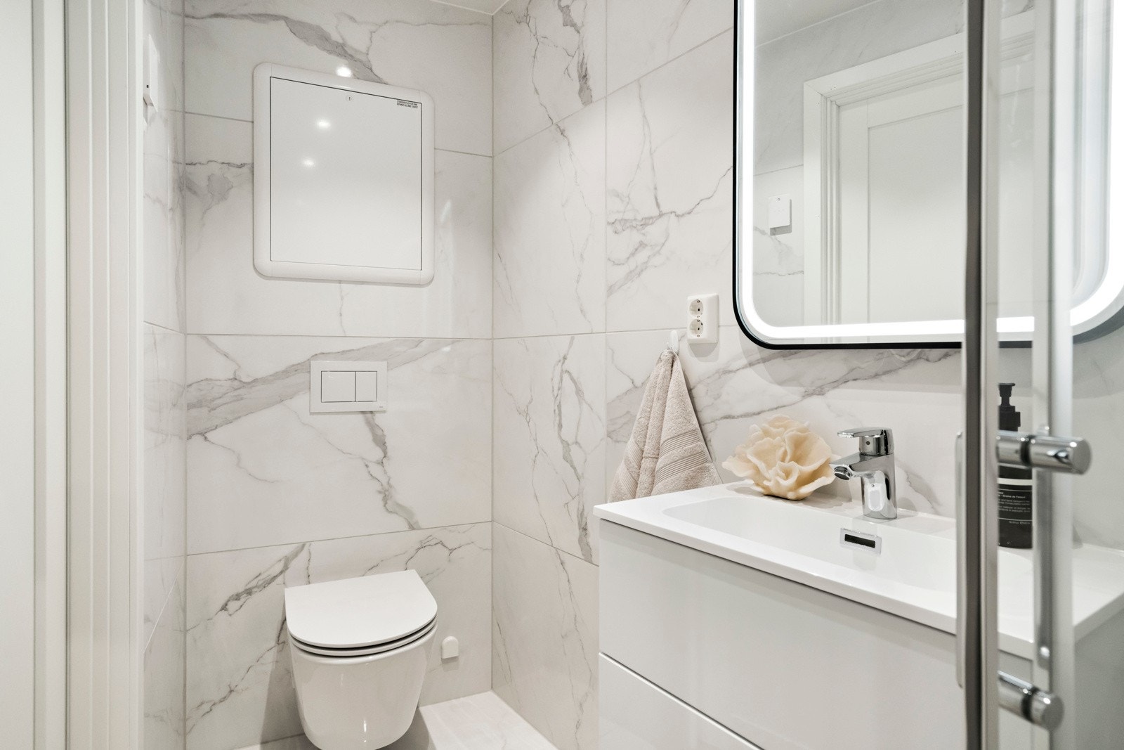 Delikate fliser fra Porcellanato i 120 x 60 cm format på vegger. Gulv også med 120 x 60 cm fliser og 5 x 5 cm fliser i nedsenket dusjområde. Galleribilde