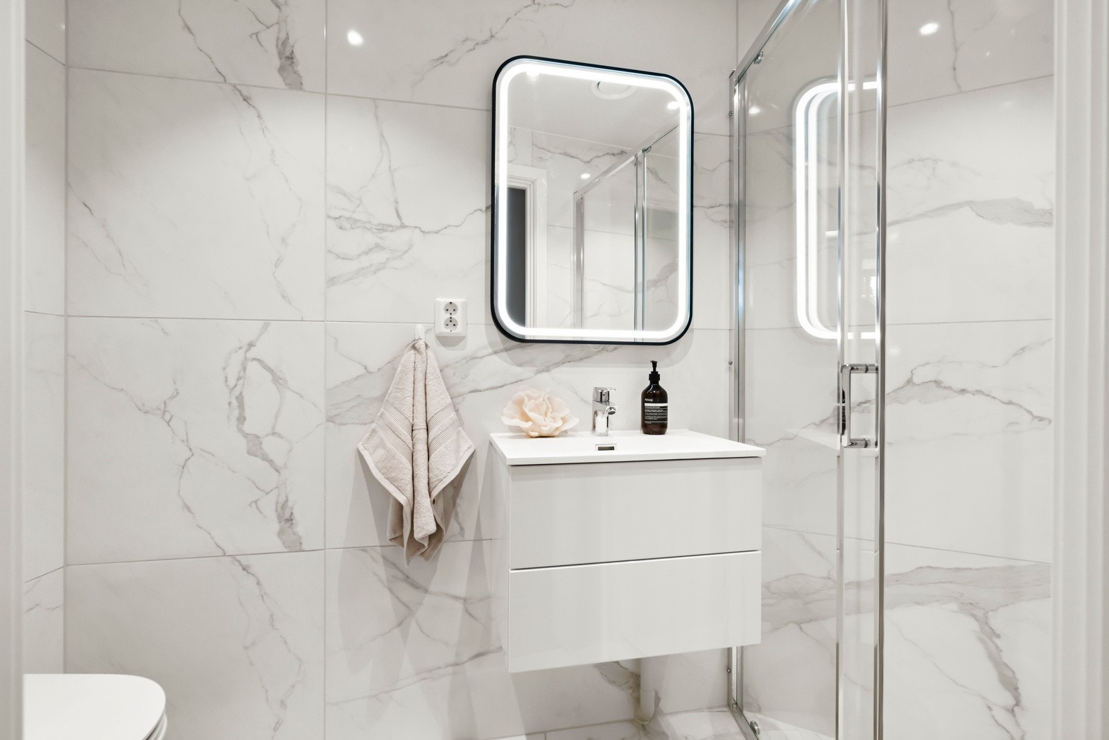 Bad 2. Stilig, nytt bad (bygget i 2025). Baderomsinnredning med nedfelt servant med to skuffer med veggmontert speil over med integrert belysning. Elektriske varmekabler i gulv (vannbåren varme under), samt balansert ventilasjon med avtrekk via ventil. Galleribilde