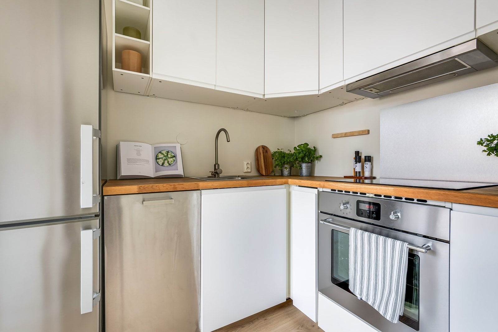 Separat kjøkken med hvite fronter og heltré benkeplate Galleribilde