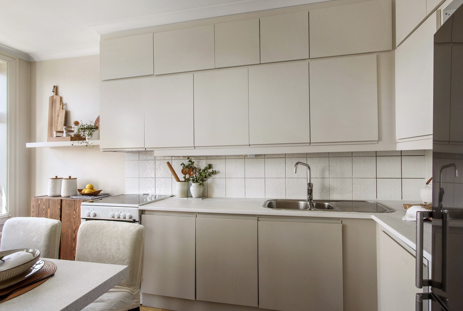 Kjøkkenet er utstyrt med takhøye kjøkkenskap, benkeplate i laminat og frittstående hvitevarer Galleribilde