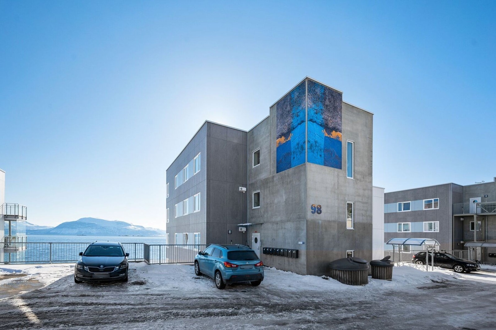 Hovedinngang og fellesområde med asfalterte områder og parkeringsplasser Galleribilde